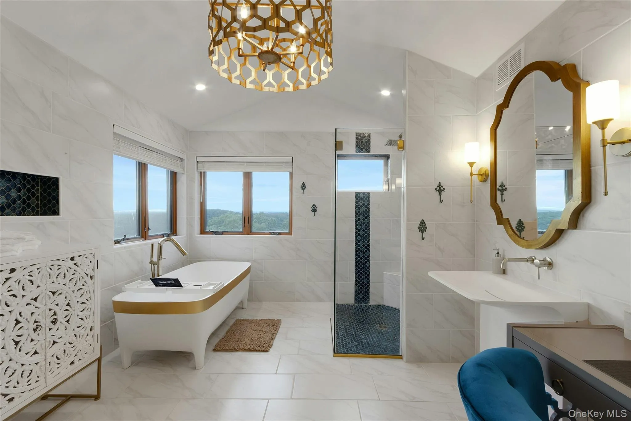 Freestanding soaking tub, walk-in shower with glass enclosure, single vanity with wall-mounted faucet, and a decorative overhead light fixture Freestanding soaking tub, walk-in shower with glass enclosure, single vanity with wall-mounted faucet, and a decorative overhead light fixture
