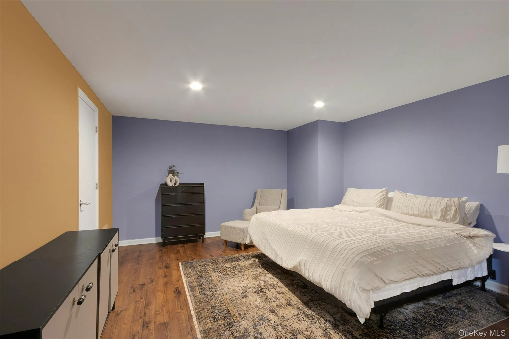 Recessed lighting, wood-finish flooring, and a white door with contemporary hardware Recessed lighting, wood-finish flooring, and a white door with contemporary hardware