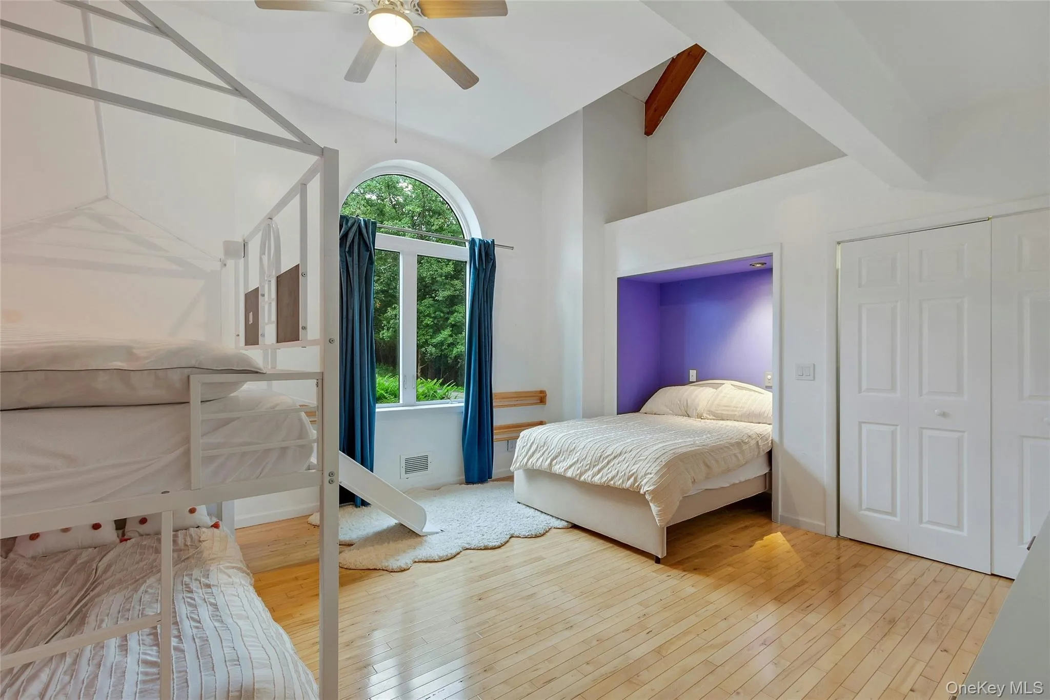 Hardwood flooring, vaulted ceilings with exposed beams, arched window, built-in bed nook, and ceiling fan Hardwood flooring, vaulted ceilings with exposed beams, arched window, built-in bed nook, and ceiling fan