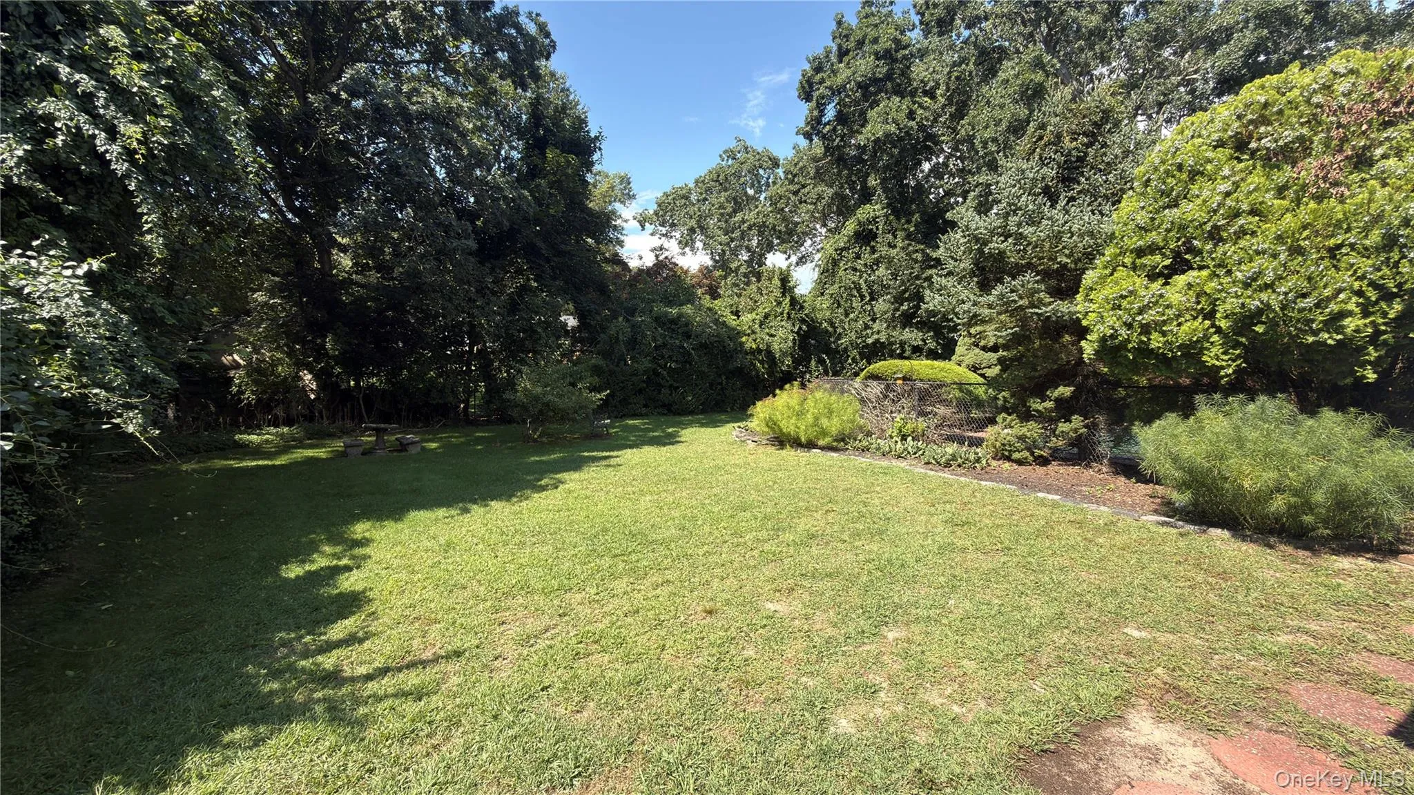 Expansive park like yard surrounded by mature trees and established landscaping Expansive park like yard surrounded by mature trees and established landscaping