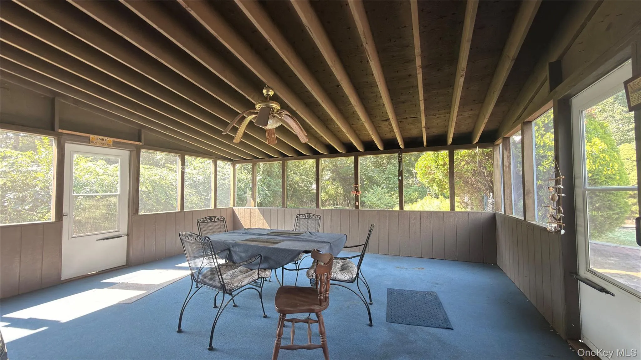 Screened porch featuring a slatted wood ceiling, ceiling fan, and extensive natural light Screened porch featuring a slatted wood ceiling, ceiling fan, and extensive natural light