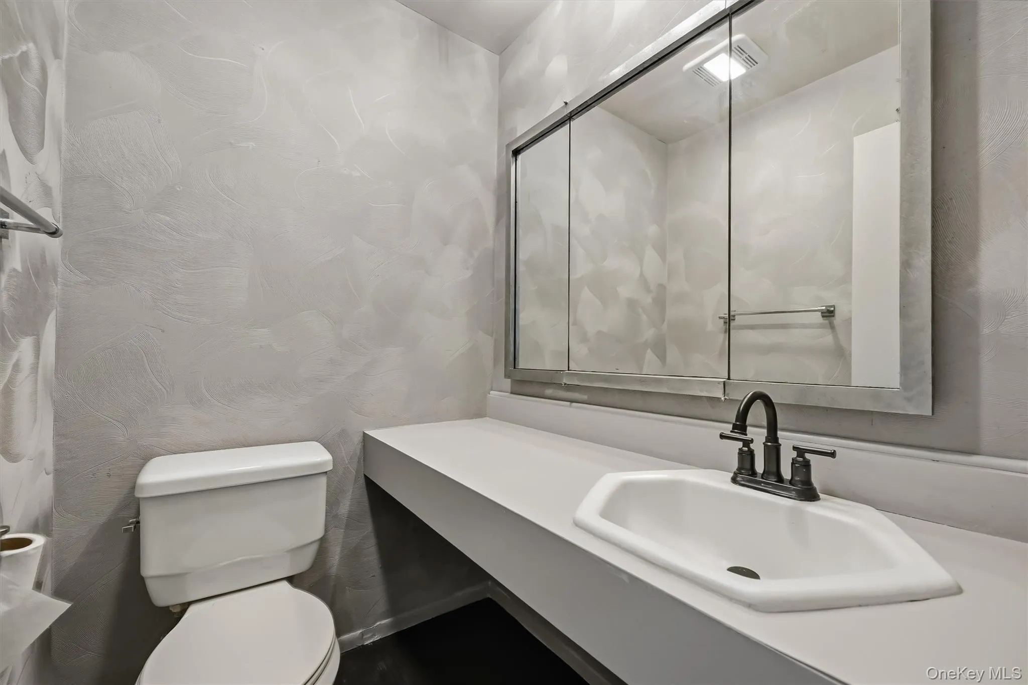 Private primary-bedroom lavatory with an extended vanity and mirrored cabinet. Private primary-bedroom lavatory with an extended vanity and mirrored cabinet.