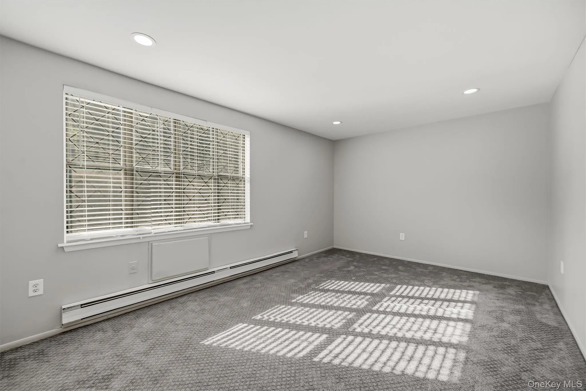 Primary bedroom with recessed lighting, carpeting, and a large window. Primary bedroom with recessed lighting, carpeting, and a large window.