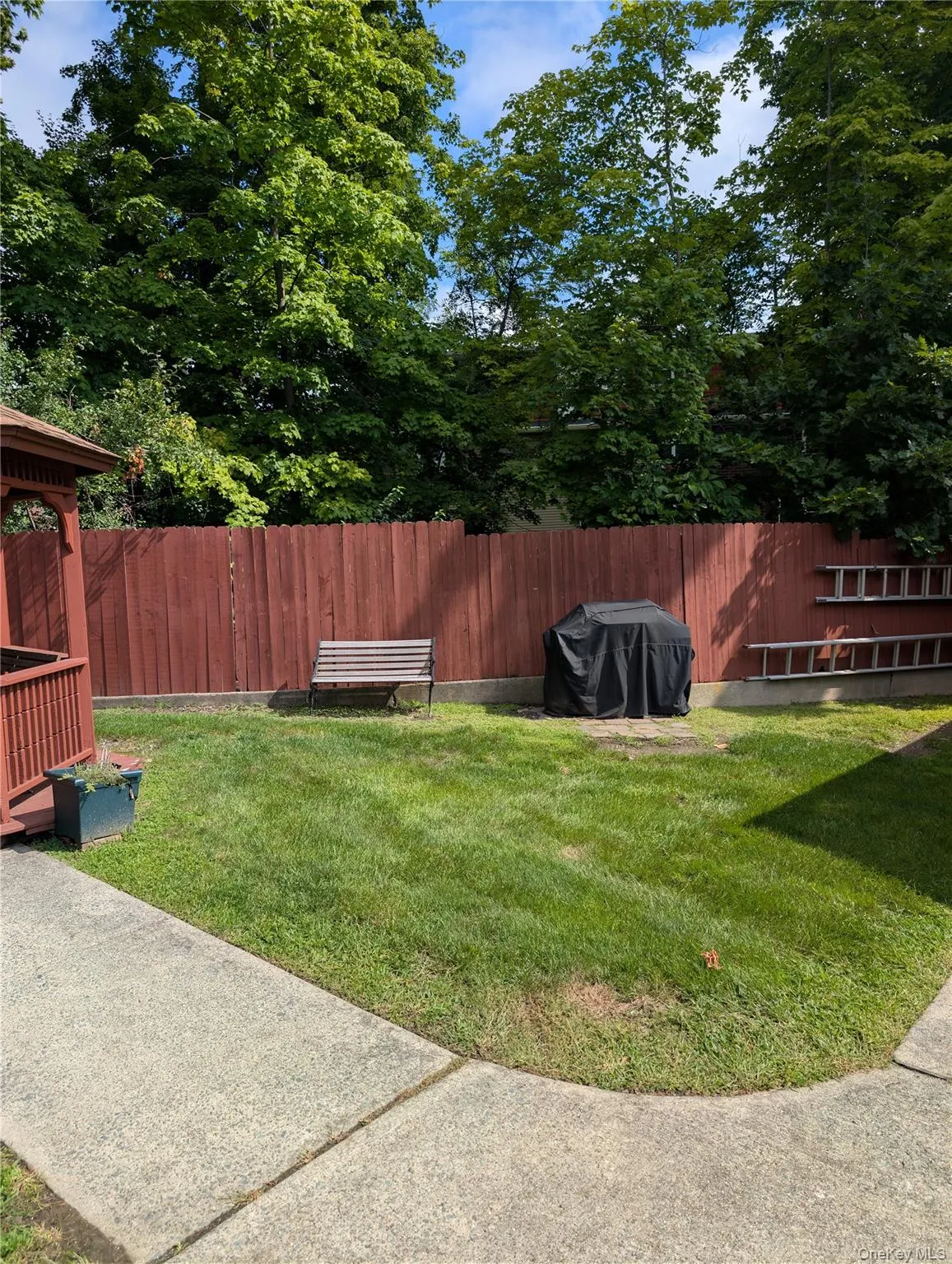 Gas grill and bench located near the gazebo and pool Gas grill and bench located near the gazebo and pool