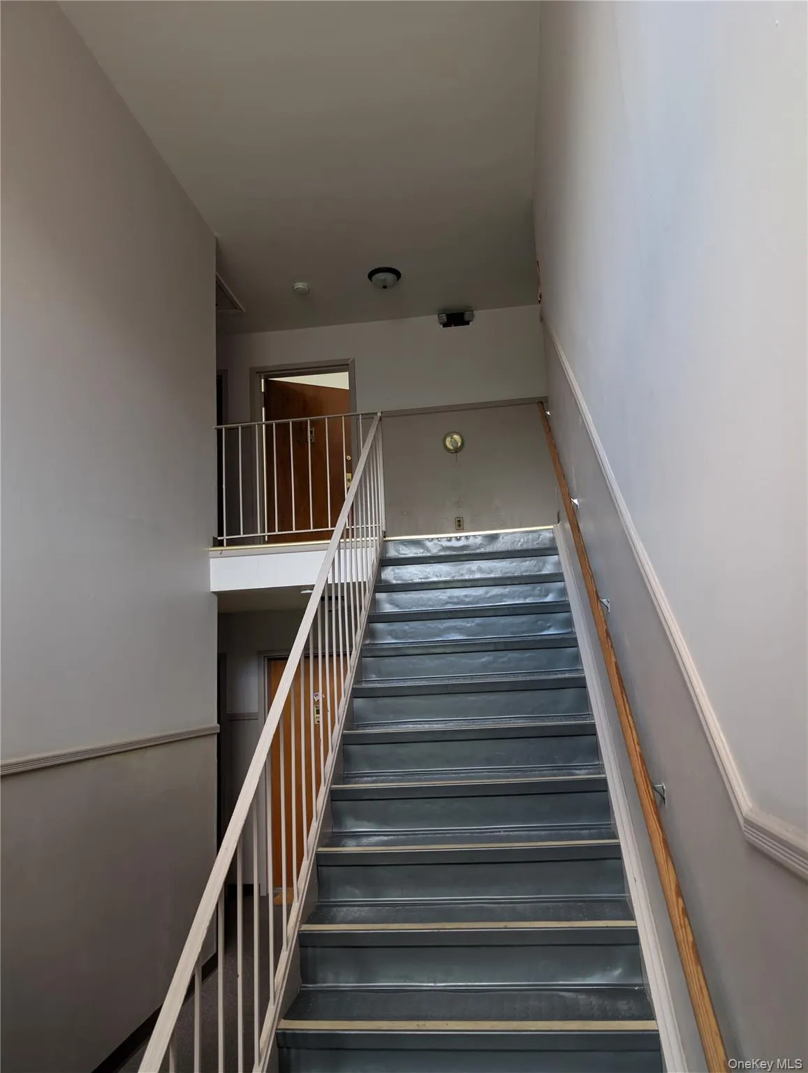 Stairwell with painted walls and a light-colored railing Stairwell with painted walls and a light-colored railing