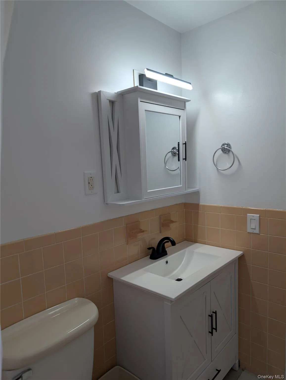 New white vanity with an integrated sink, matte black faucet, and white wall-mounted medicine cabinet with a mirrored door New white vanity with an integrated sink, matte black faucet, and white wall-mounted medicine cabinet with a mirrored door