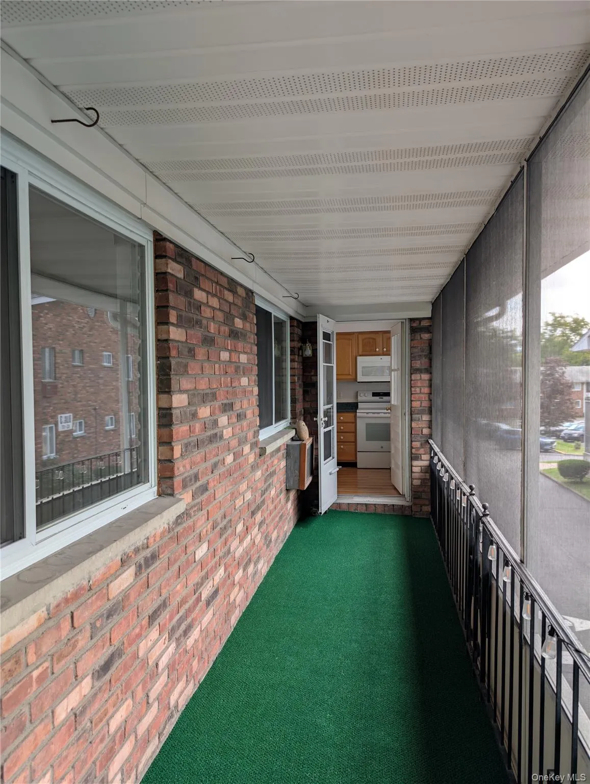 Screened porch with indoor/outdoor carpeting and entrance to the kitchen Screened porch with indoor/outdoor carpeting and entrance to the kitchen