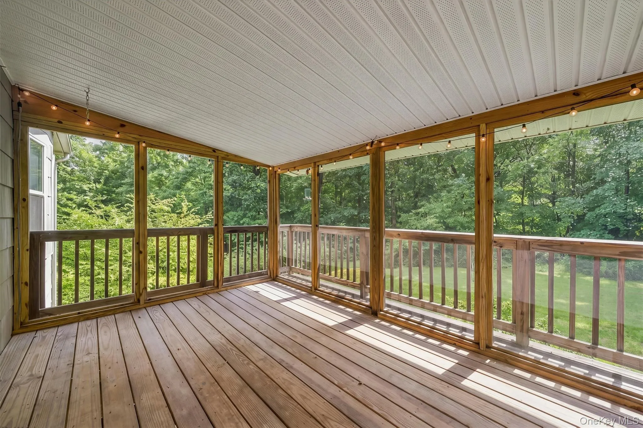 Screened porch with wood-finish flooring, wood railings, and a paneled ceiling Screened porch with wood-finish flooring, wood railings, and a paneled ceiling