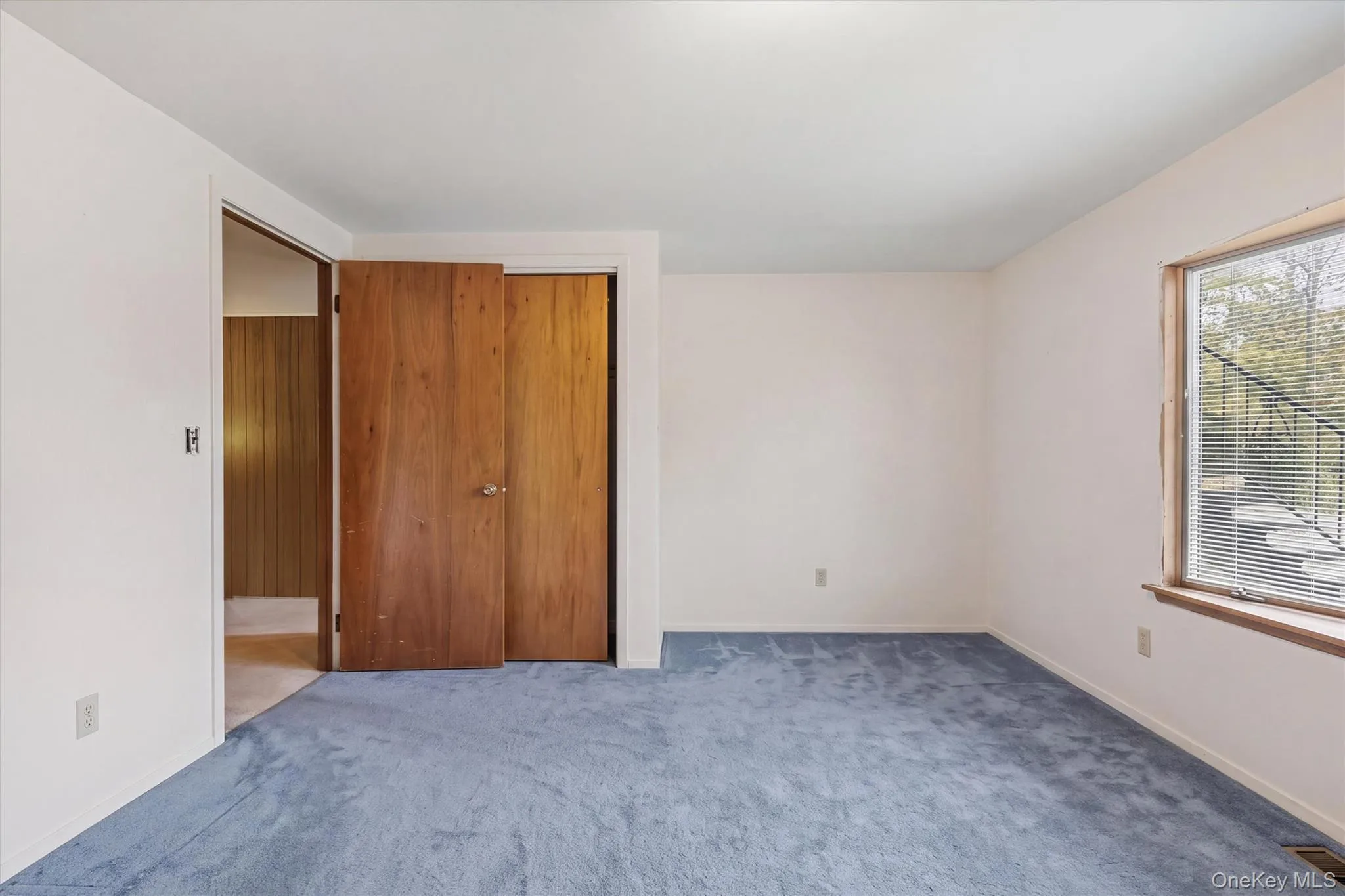 Bedroom 4 -- Neutral wall paint, carpet, wood-finish doors, and a window Bedroom 4 -- Neutral wall paint, carpet, wood-finish doors, and a window