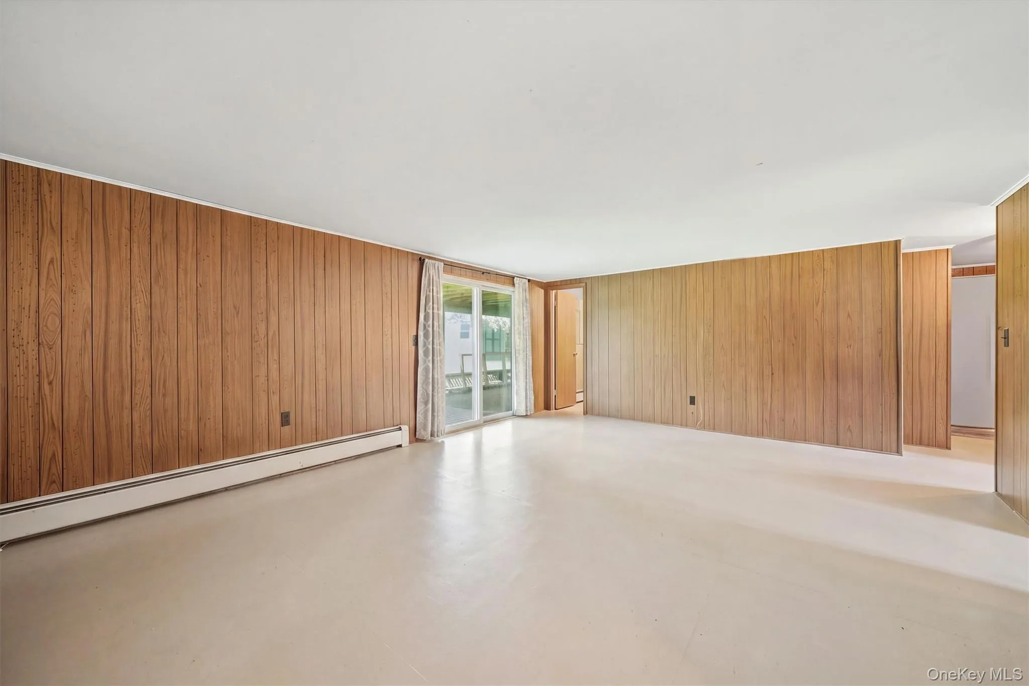 Wood-paneled walls and neutral flooring Wood-paneled walls and neutral flooring