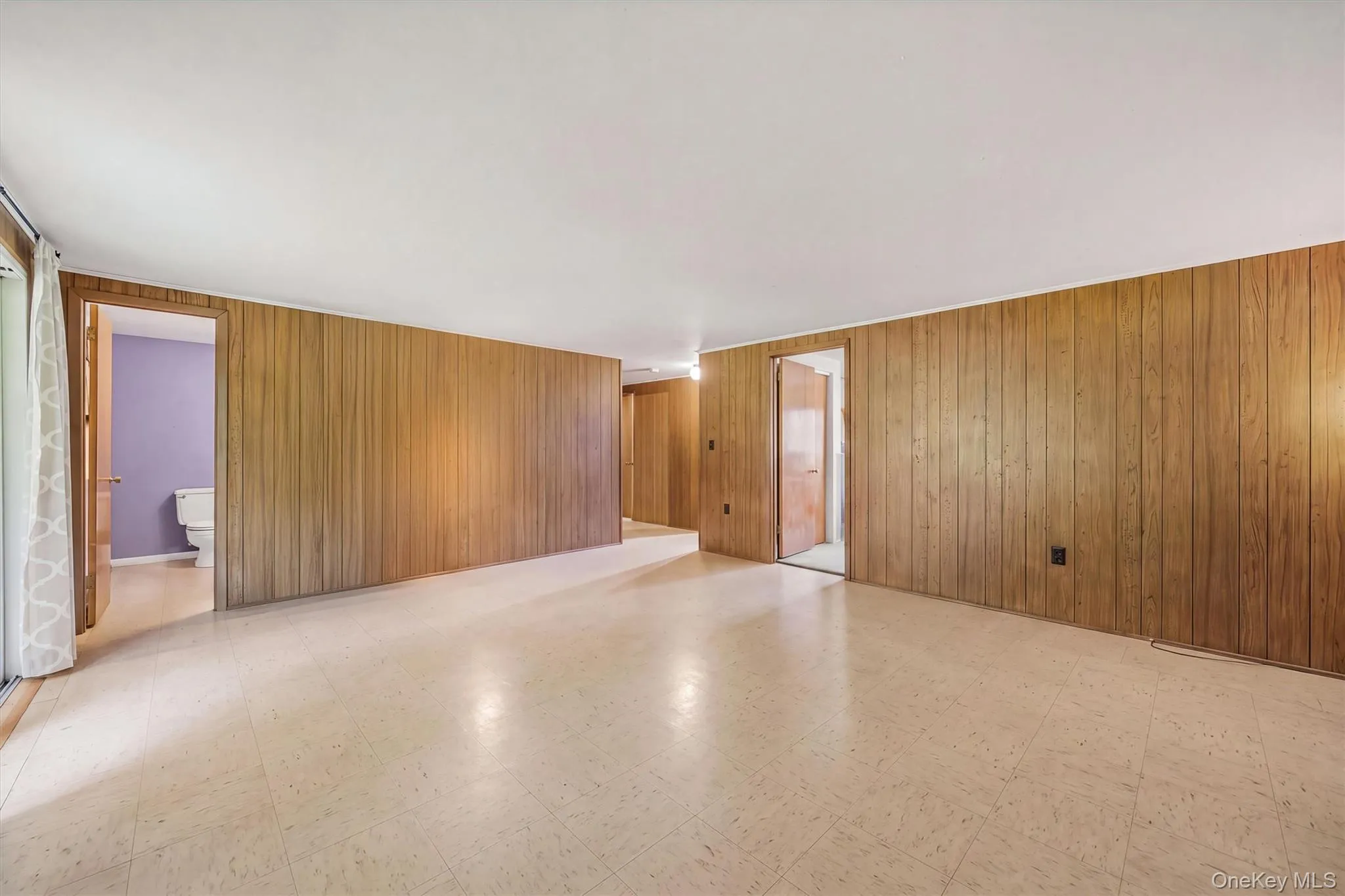 Wood-panel accent wall and light-toned flooring Wood-panel accent wall and light-toned flooring
