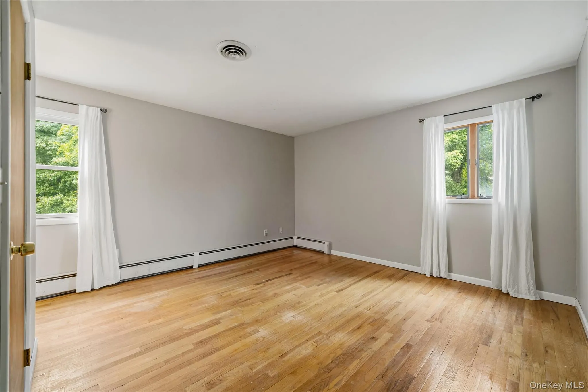 Hardwood flooring, painted walls, and two windows with white trim Hardwood flooring, painted walls, and two windows with white trim