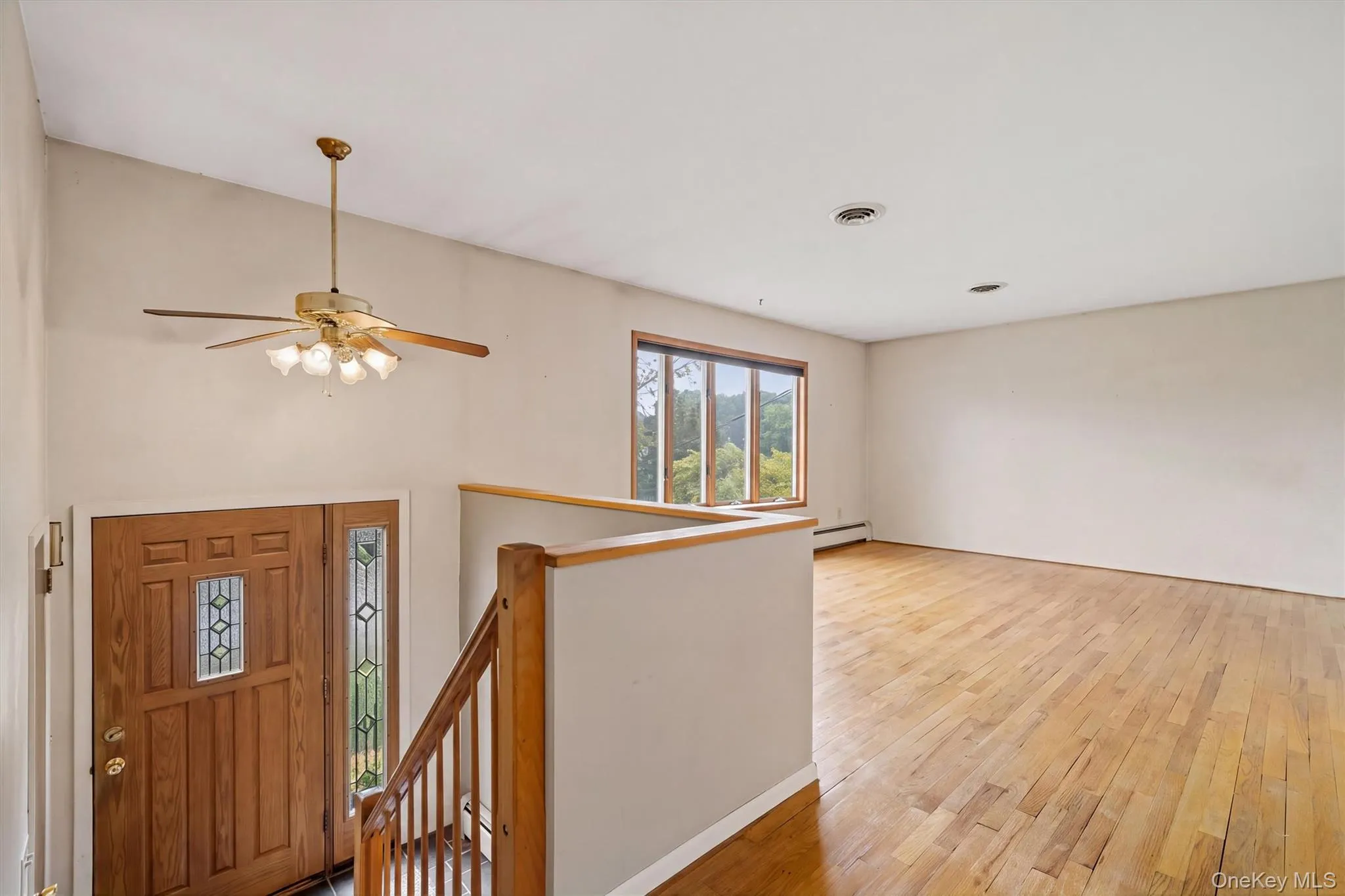 Hardwood flooring throughout, a multi-pane window, and a ceiling fan with integrated lighting Hardwood flooring throughout, a multi-pane window, and a ceiling fan with integrated lighting