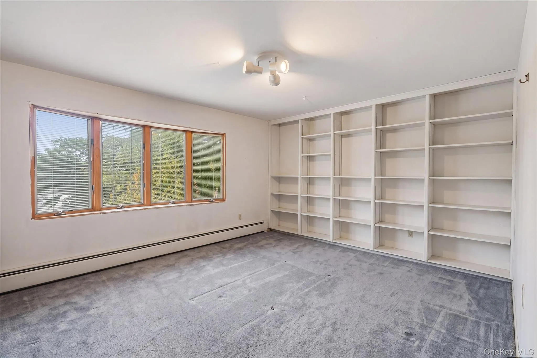 Bedroom 4 Expansive built-in shelving, wood-framed windows, and track lighting Bedroom 4 Expansive built-in shelving, wood-framed windows, and track lighting