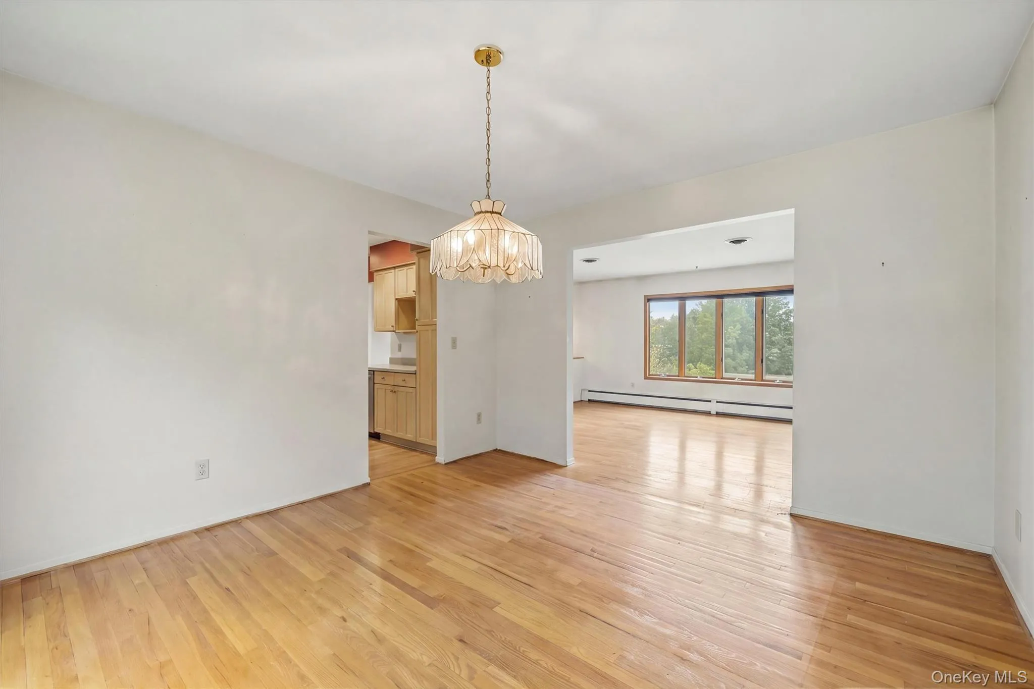 Hardwood flooring, recessed lighting, and a chandelier in an open-concept interior Hardwood flooring, recessed lighting, and a chandelier in an open-concept interior