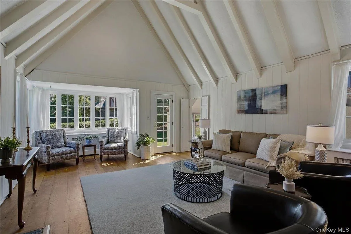 Dramatic living room with soaring cathedral ceilings, abundant natural light, and a wood-burning fireplace leading into additional sitting room. Dramatic living room with soaring cathedral ceilings, abundant natural light, and a wood-burning fireplace leading into additional sitting room.