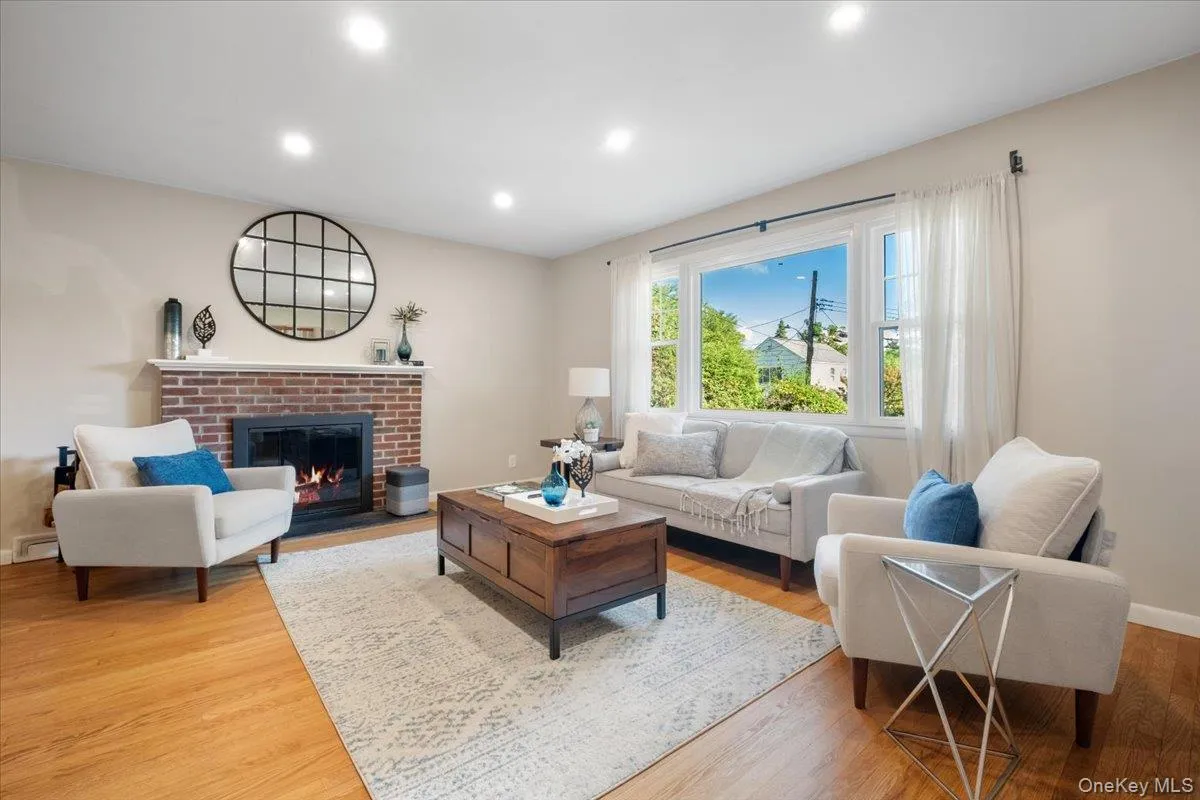 Hardwood flooring, recessed lighting, brick fireplace with mantel, and a large bay window Hardwood flooring, recessed lighting, brick fireplace with mantel, and a large bay window
