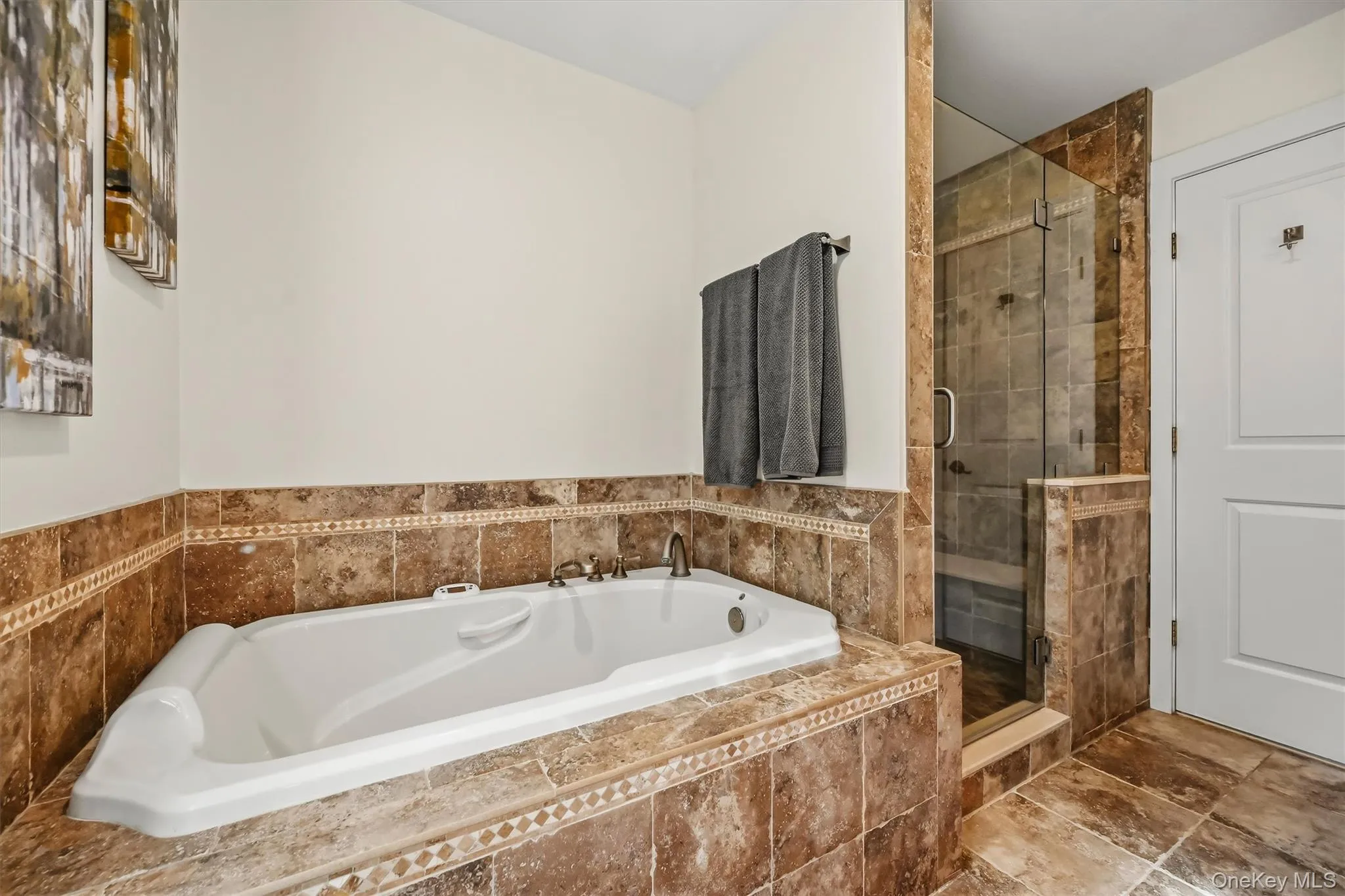 Spa-like primary bath featuring a luxurious soaking tub and separate tiled walk-in shower. Spa-like primary bath featuring a luxurious soaking tub and separate tiled walk-in shower.