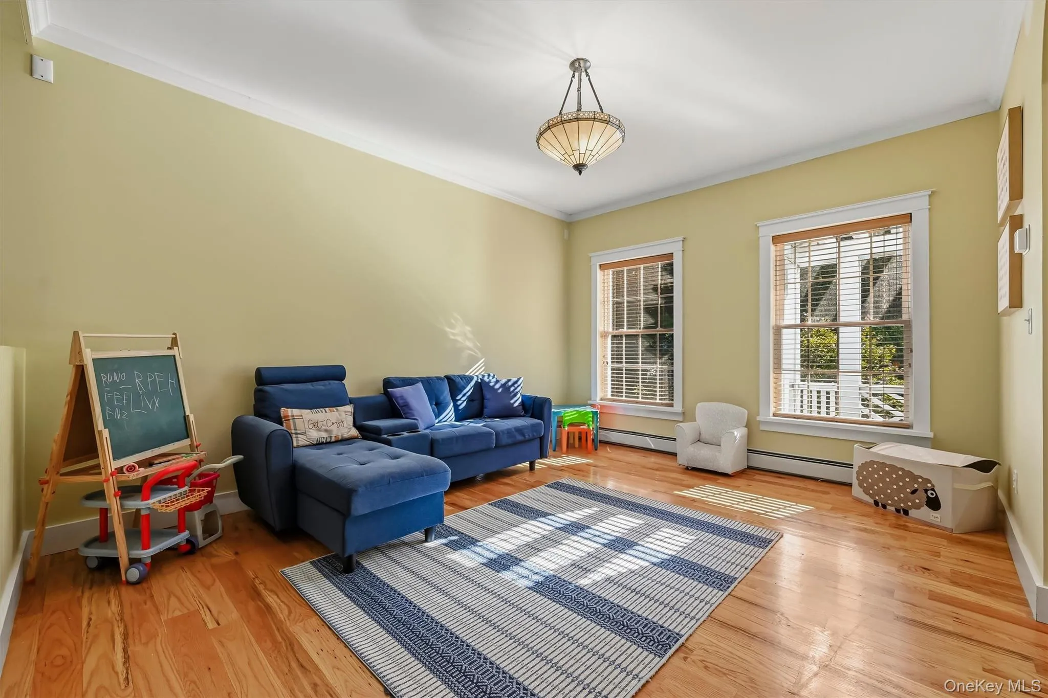 Inviting living room with hardwood floors, crown molding, and natural wood blinds. Inviting living room with hardwood floors, crown molding, and natural wood blinds.