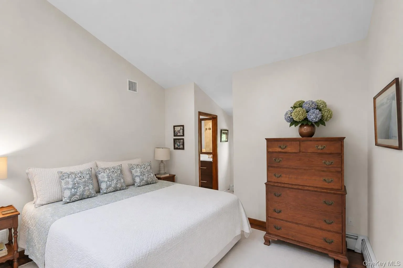 Vaulted ceiling, light neutral wall color, carpeted flooring, and wood trim details Vaulted ceiling, light neutral wall color, carpeted flooring, and wood trim details