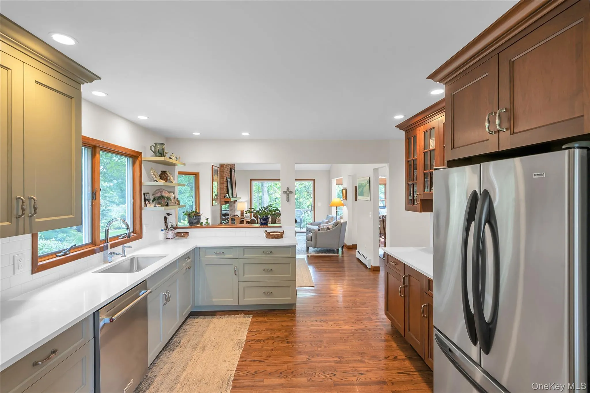 Kitchen featuring hardwood flooring, recessed lighting, quartz countertops, stainless steel appliances, and a tile backsplash Kitchen featuring hardwood flooring, recessed lighting, quartz countertops, stainless steel appliances, and a tile backsplash