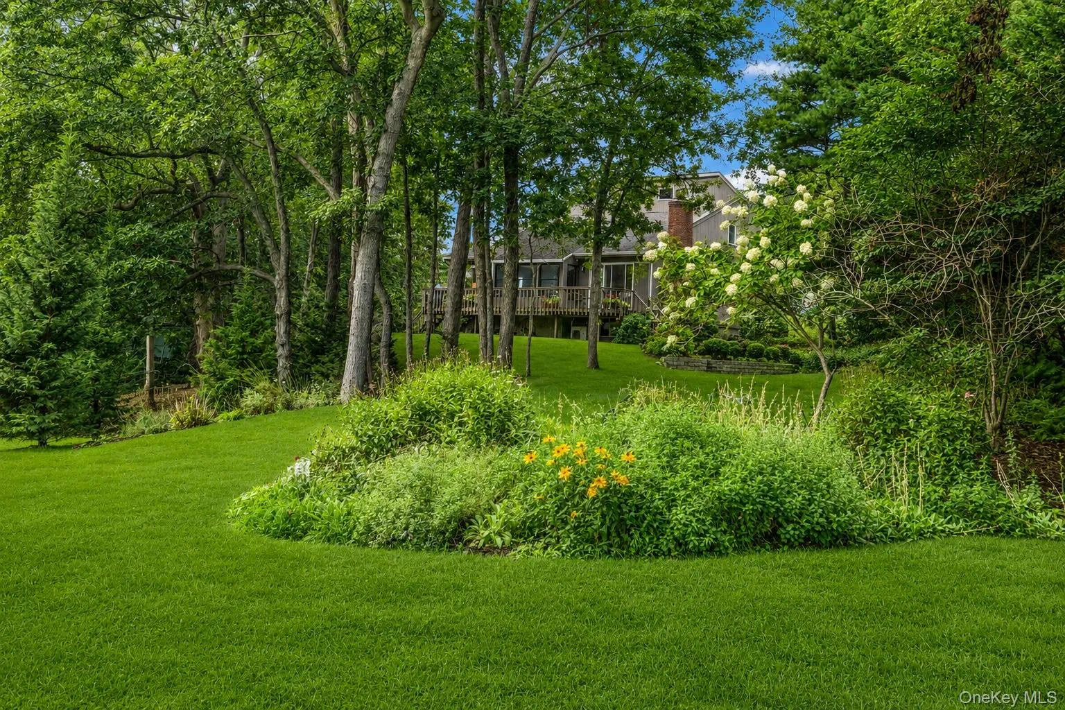 Expansive lawn area with mature trees and established landscaping leading to creek Expansive lawn area with mature trees and established landscaping leading to creek