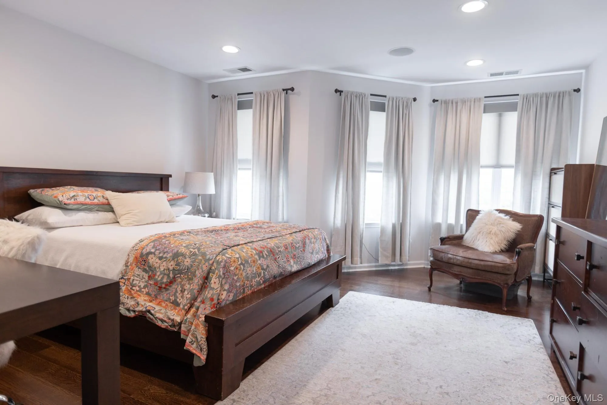 Oversized windows in a spacious primary bedroom with two oversized closets and an ensuite bath with tiled and glass shower and soaking tub. Oversized windows in a spacious primary bedroom with two oversized closets and an ensuite bath with tiled and glass shower and soaking tub.