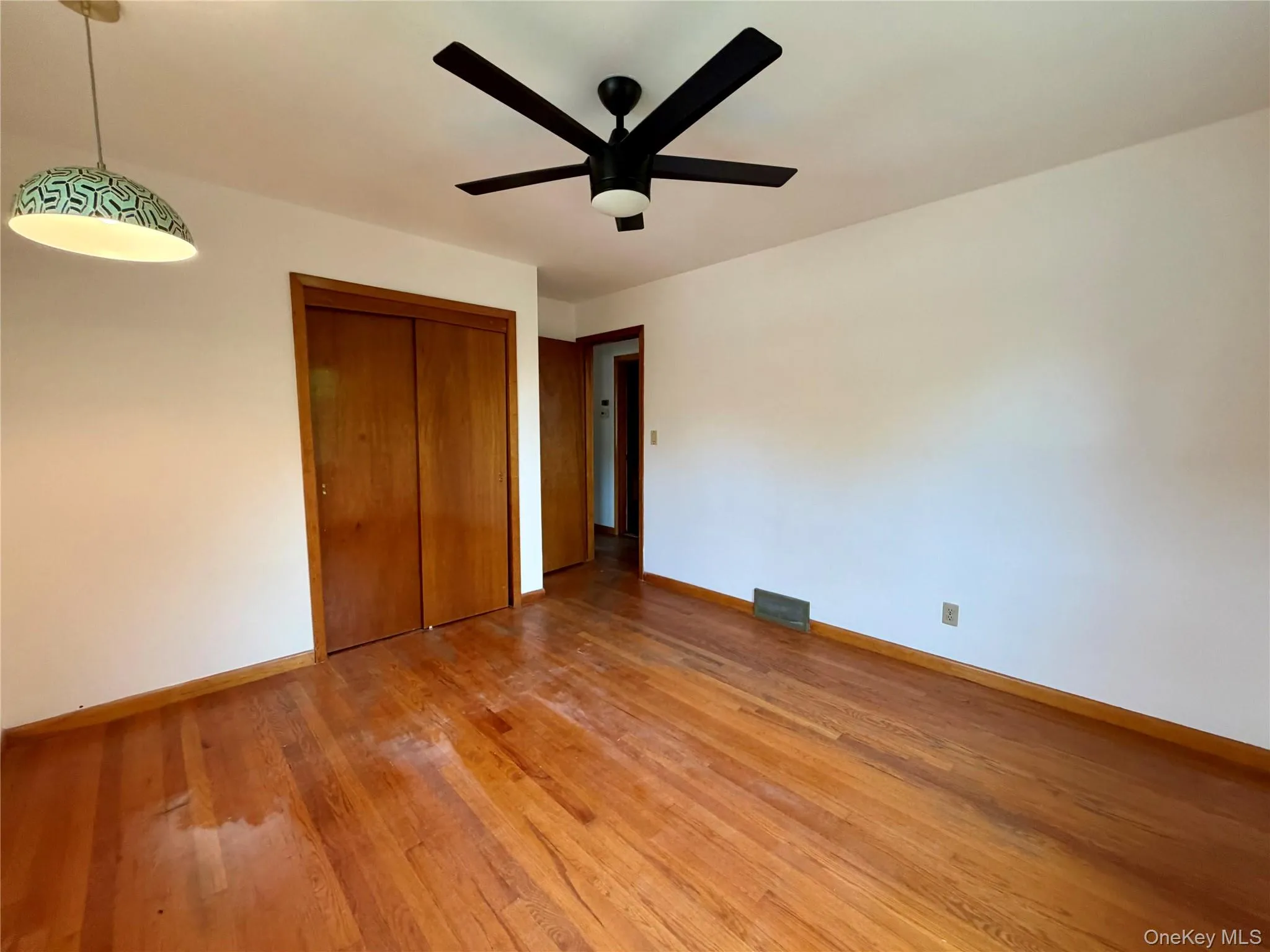Hardwood flooring, white walls, and a ceiling fan with light fixture Hardwood flooring, white walls, and a ceiling fan with light fixture