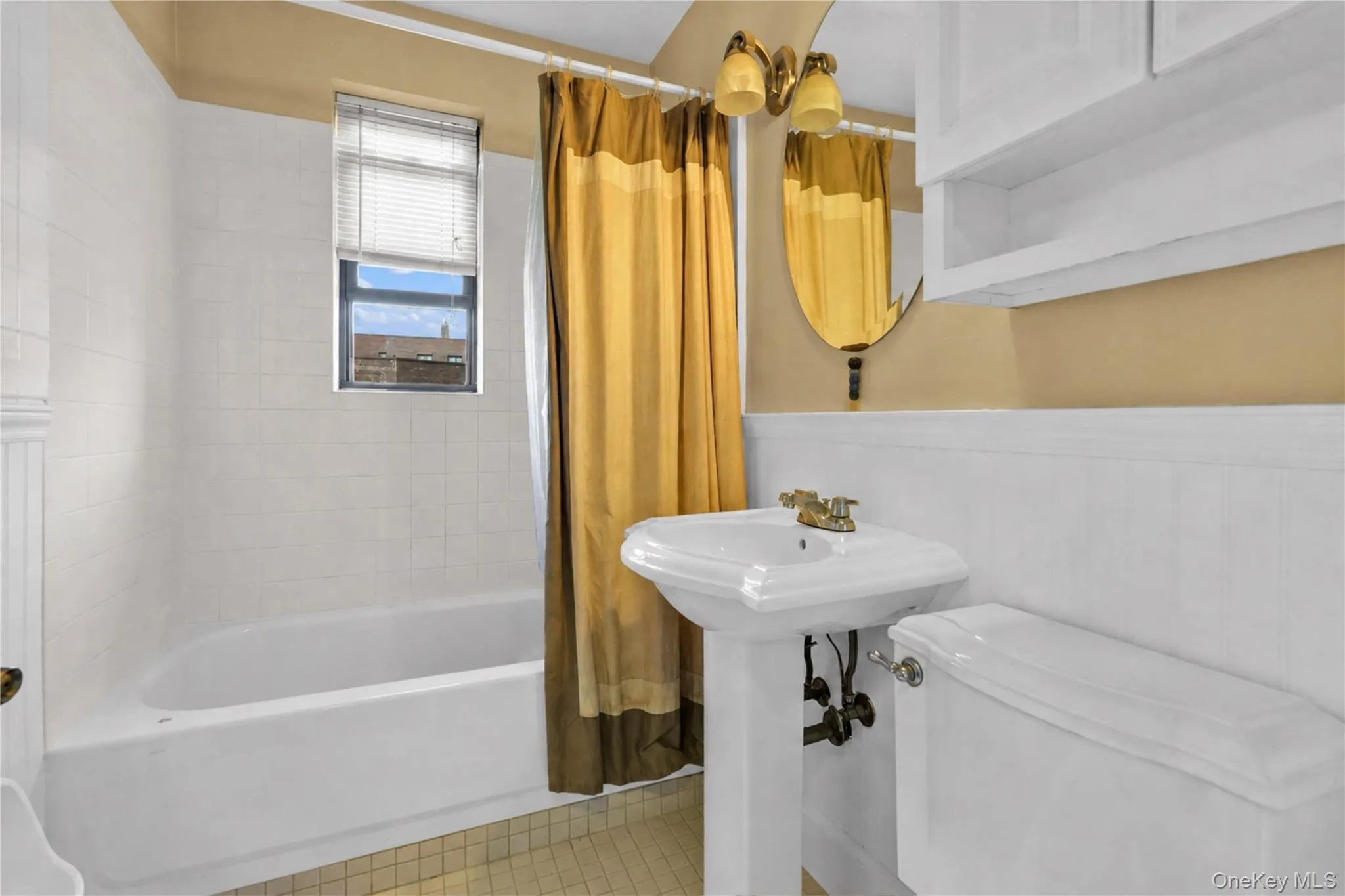 White pedestal sink with brass-finish faucet White pedestal sink with brass-finish faucet