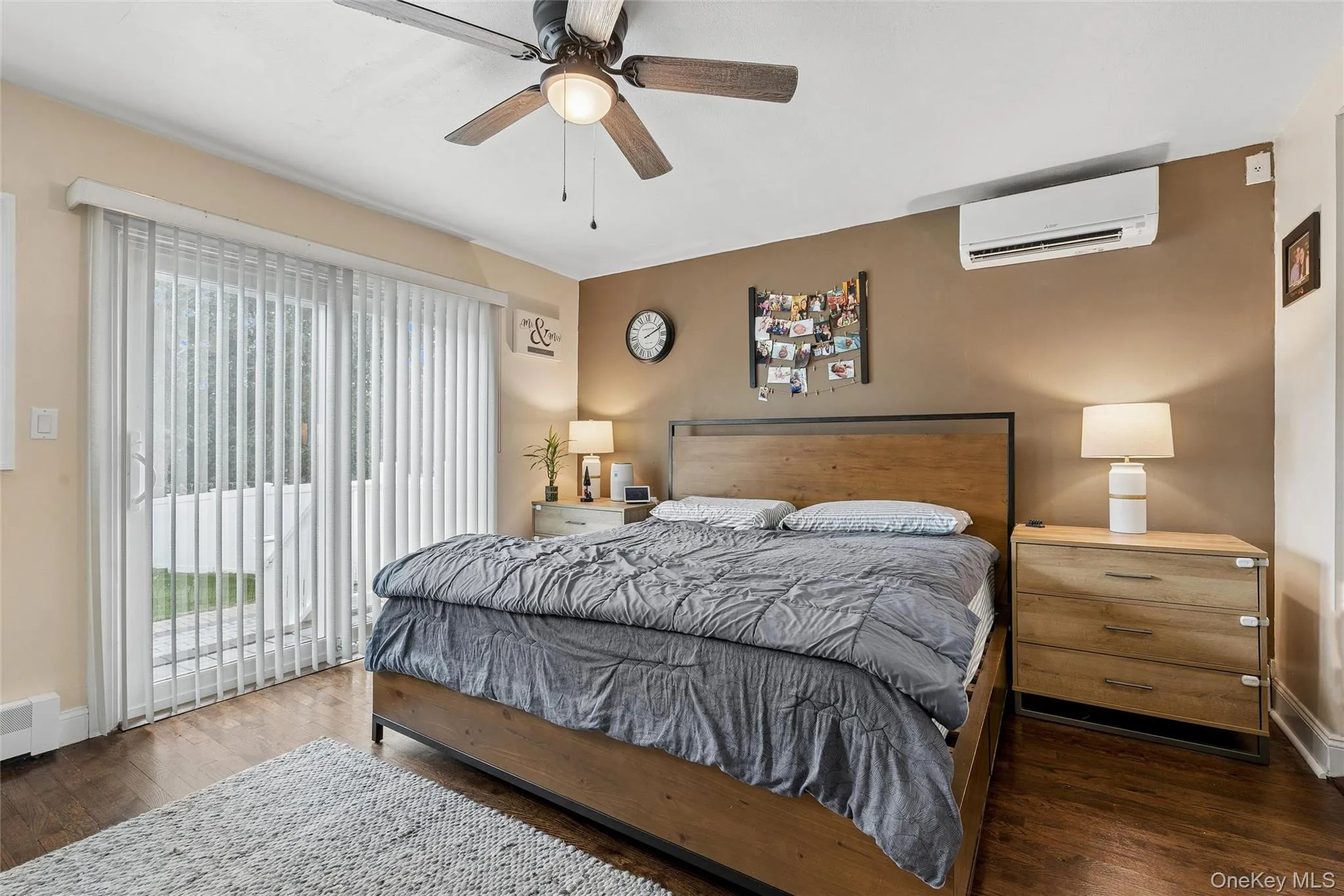 Wood-finish flooring, ceiling fan with integrated lighting, and a wall-mounted mini-split system Wood-finish flooring, ceiling fan with integrated lighting, and a wall-mounted mini-split system