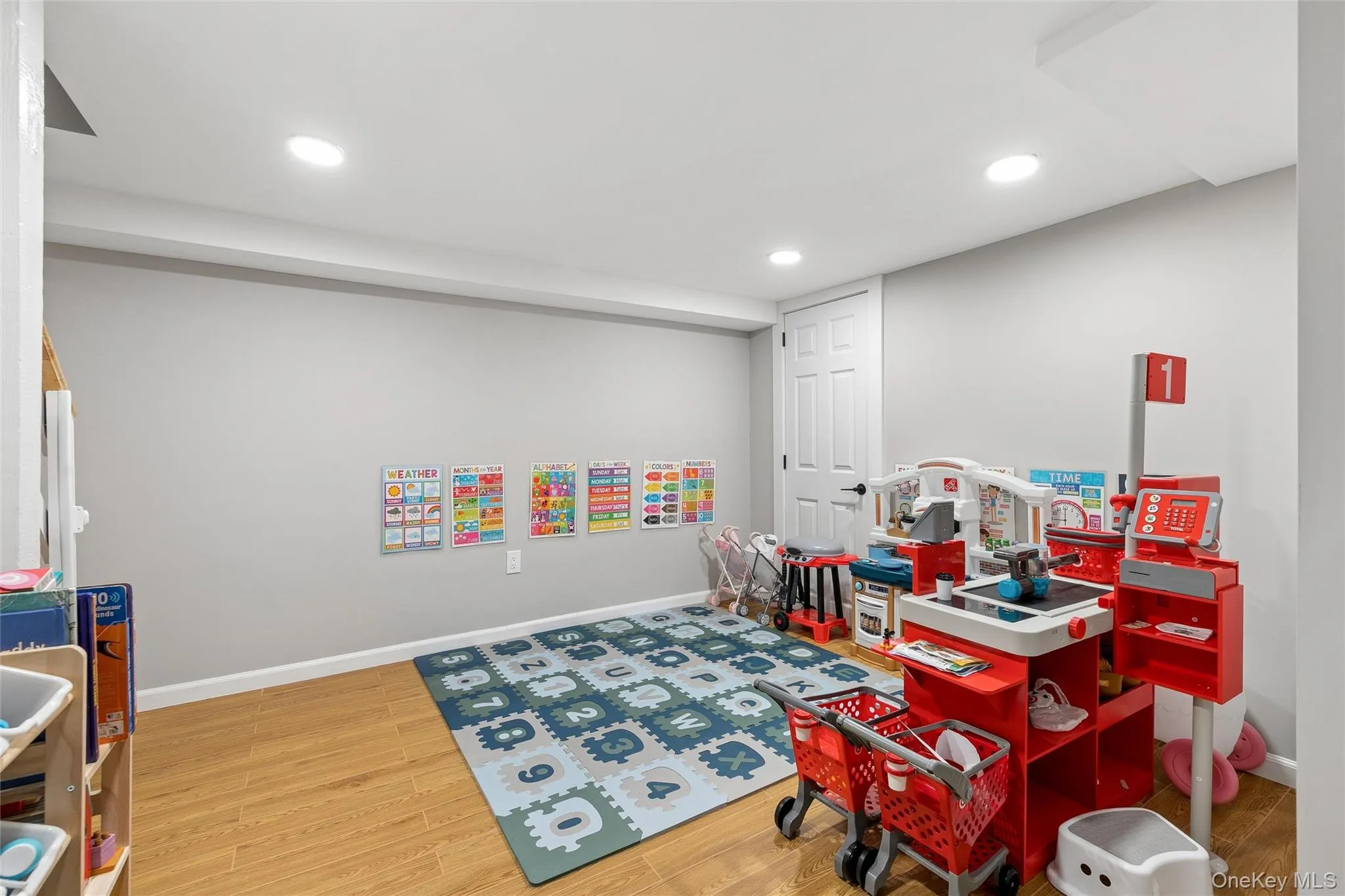 Recessed lighting illuminates this versatile room featuring light-toned wood-finish flooring and a neutral wall color Recessed lighting illuminates this versatile room featuring light-toned wood-finish flooring and a neutral wall color