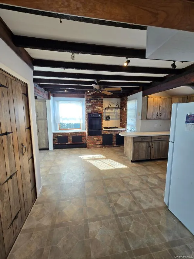 Large Eat In Kitchen With Original Beamed Ceilings, Walls Of Storage Cabinetry, A Separate Double Door Pantry, Ample Counter/Serving Space & Built In Barstool Area, Charming Brick Walls With A Built In Wall Oven & Separate Cooktop, Ample Room For A Good Sized Table & Chairs, And A Separate Mud Room With A Newer Full Sized Washer & Dryer, And Additional Storage/Cabinetry. Large Eat In Kitchen With Original Beamed Ceilings, Walls Of Storage Cabinetry, A Separate Double Door Pantry, Ample Counter/Serving Space & Built In Barstool Area, Charming Brick Walls With A Built In Wall Oven & Separate Cooktop, Ample Room For A Good Sized Table & Chairs, And A Separate Mud Room With A Newer Full Sized Washer & Dryer, And Additional Storage/Cabinetry.