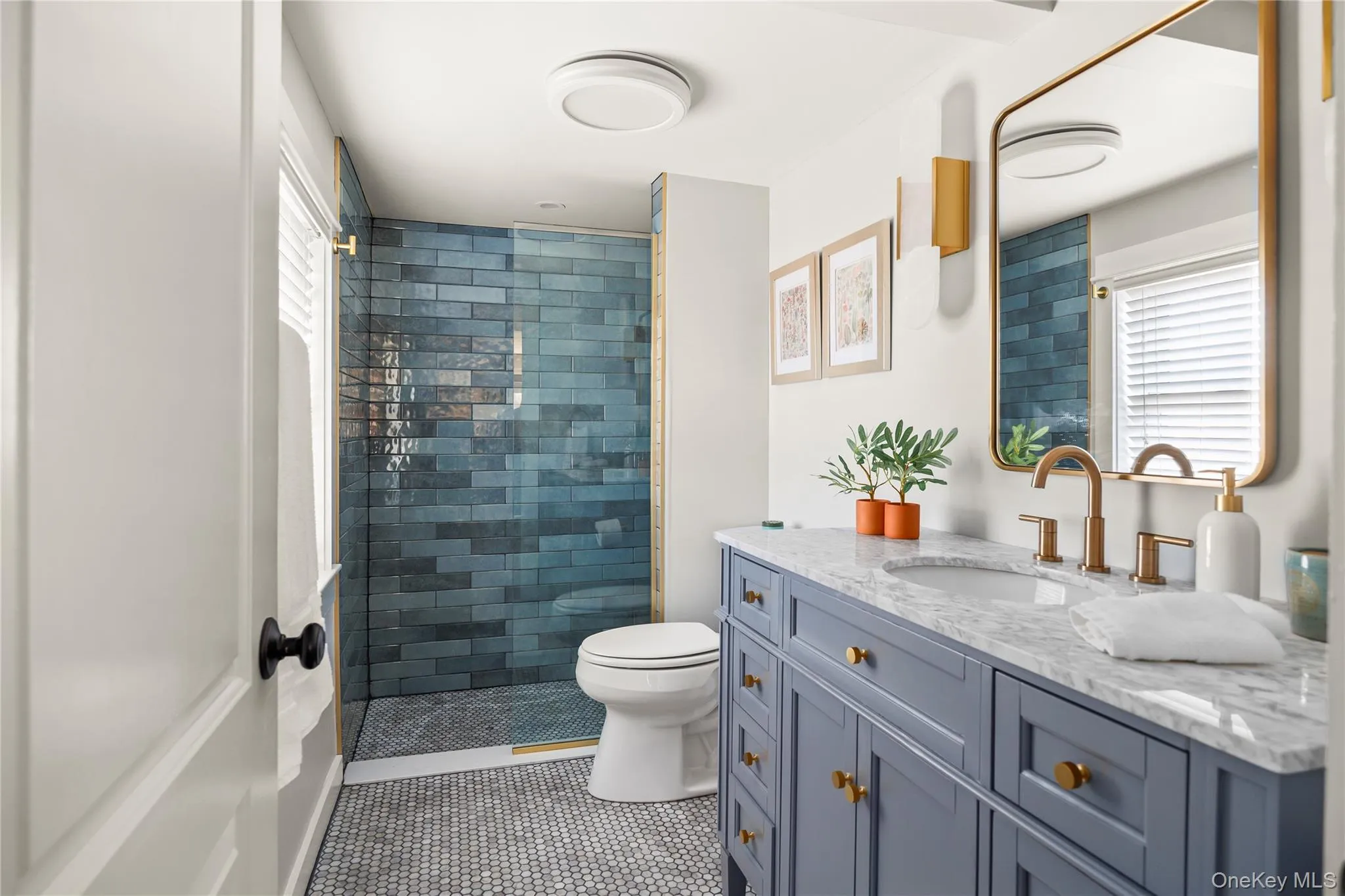 Newly renovated full bathroom with toilet, vanity, tile patterned flooring, and a tile shower Newly renovated full bathroom with toilet, vanity, tile patterned flooring, and a tile shower
