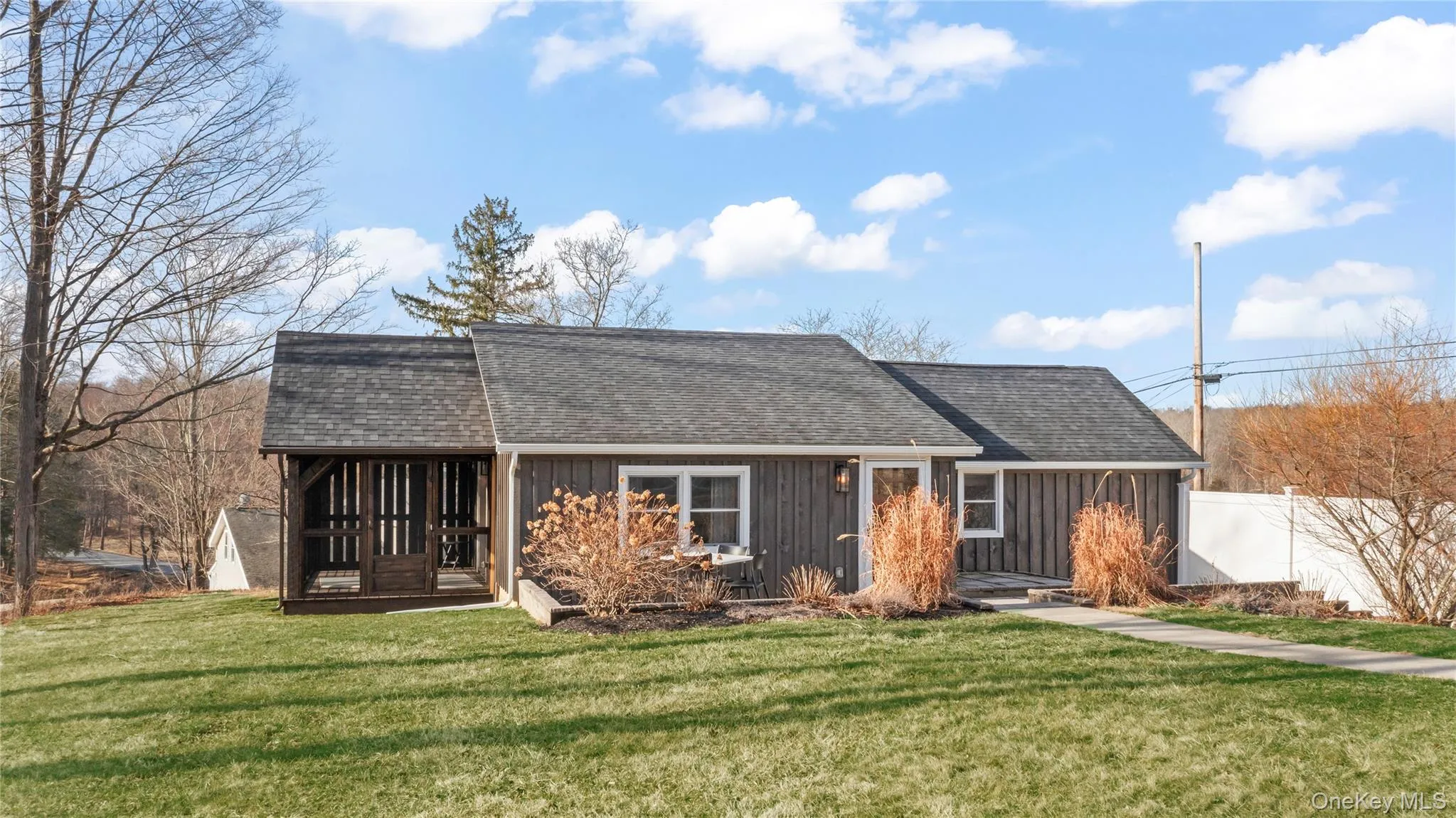 View of front of property with a screened-in porch, fence, a front lawn, board and batten siding, and shingled roof View of front of property with a screened-in porch, fence, a front lawn, board and batten siding, and shingled roof