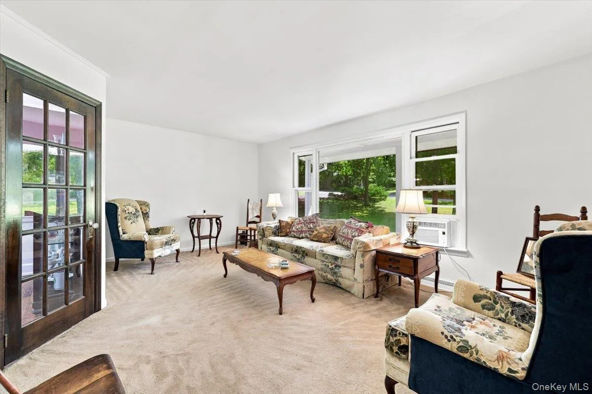 Bright and airy living room with window overlooking manicured lawn Bright and airy living room with window overlooking manicured lawn