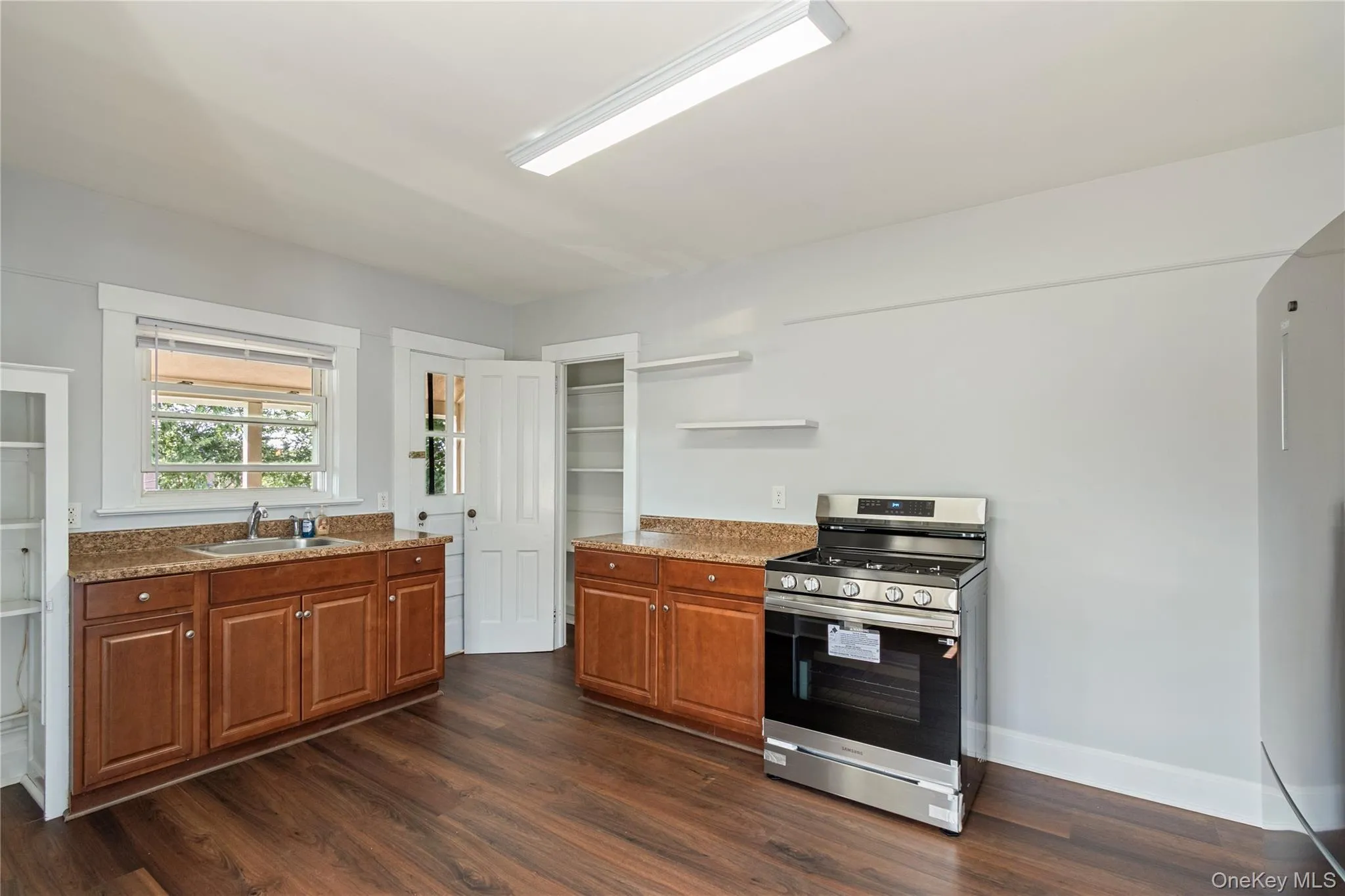 Full-size stainless steel range, wood-finish flooring, wood cabinetry, granite countertops, and built-in shelving Full-size stainless steel range, wood-finish flooring, wood cabinetry, granite countertops, and built-in shelving