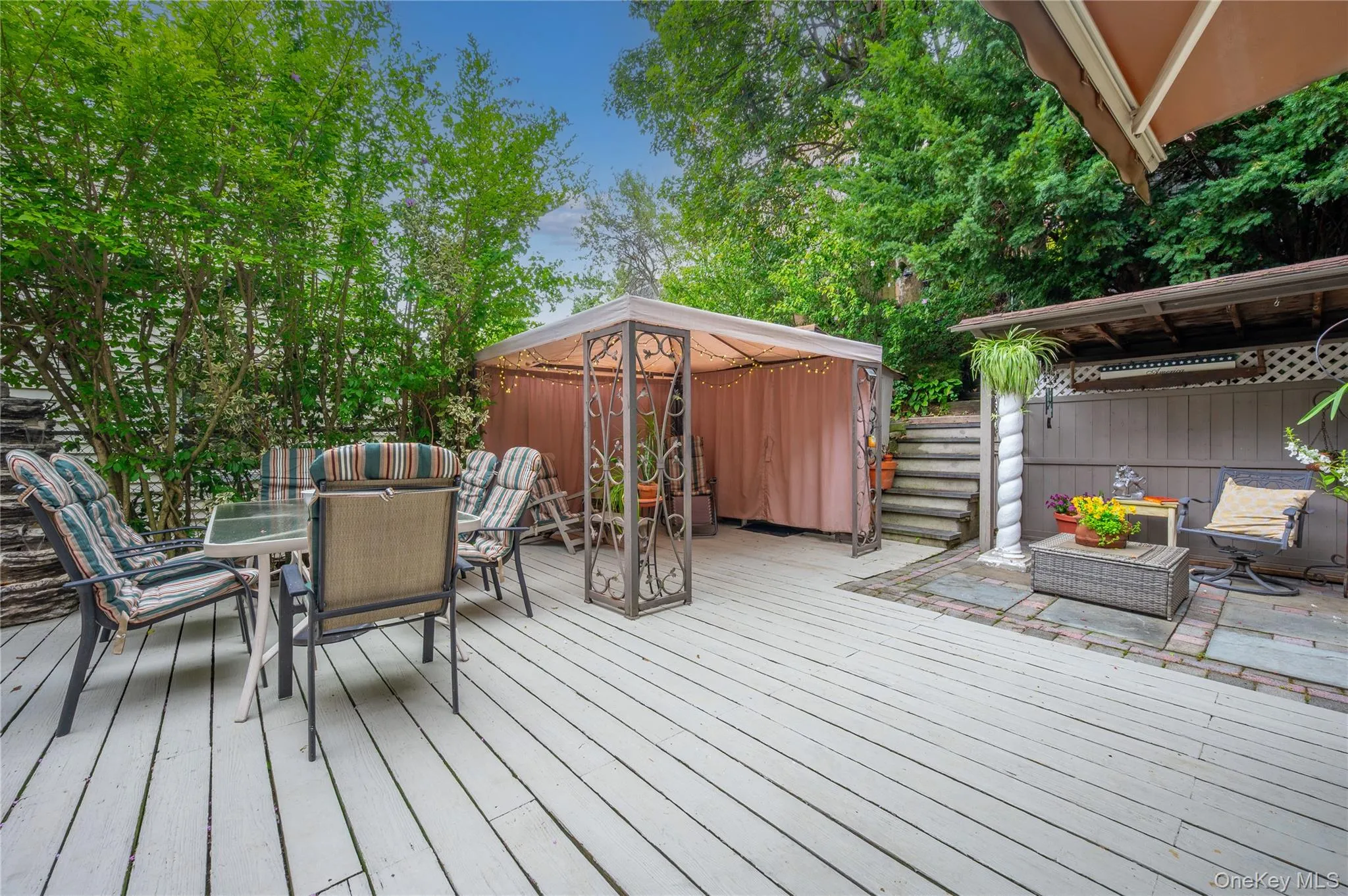 Expansive outdoor deck featuring a gazebo and mature perimeter trees Expansive outdoor deck featuring a gazebo and mature perimeter trees