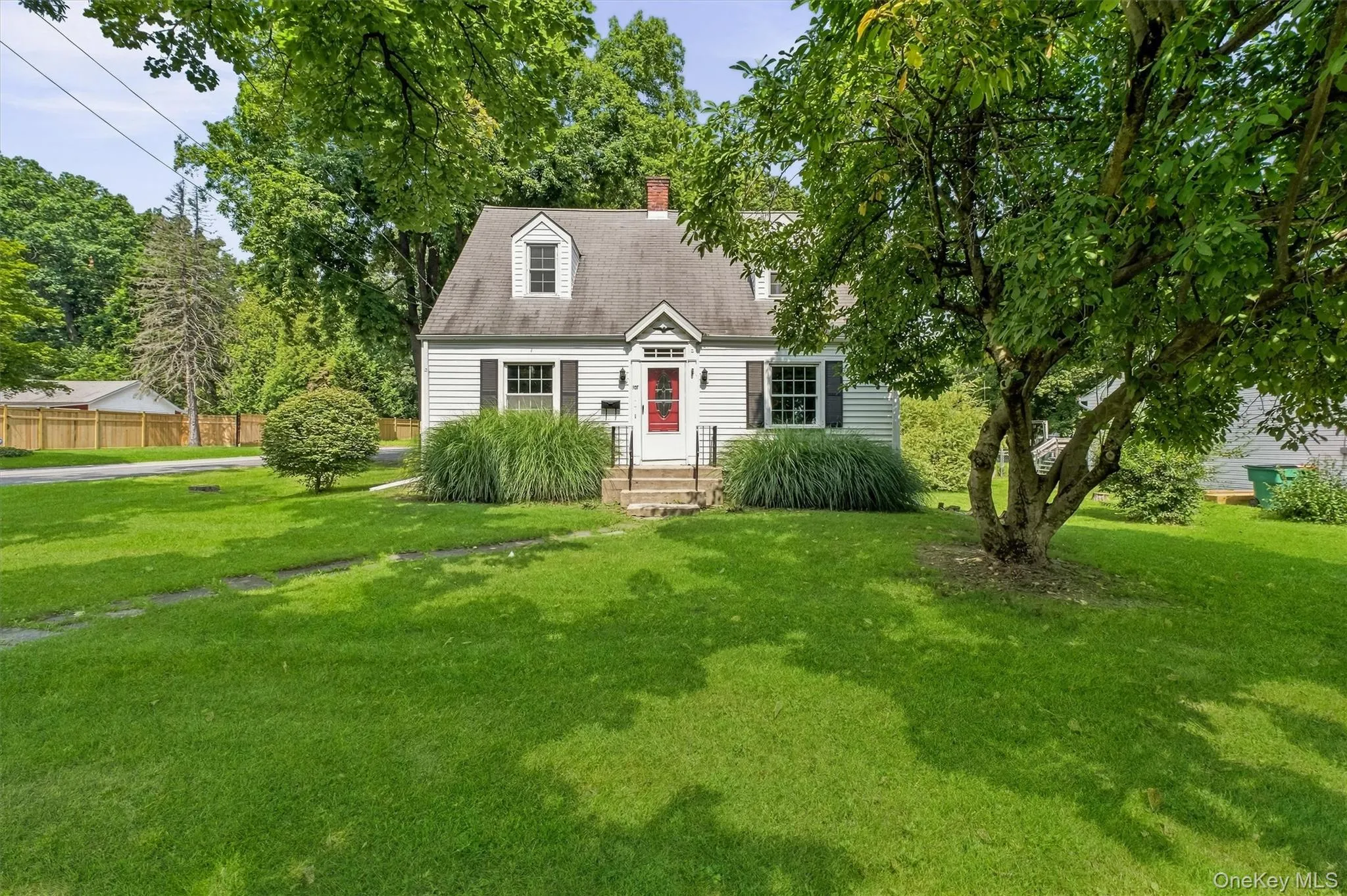 White siding exterior with black shutters and a red entry door White siding exterior with black shutters and a red entry door
