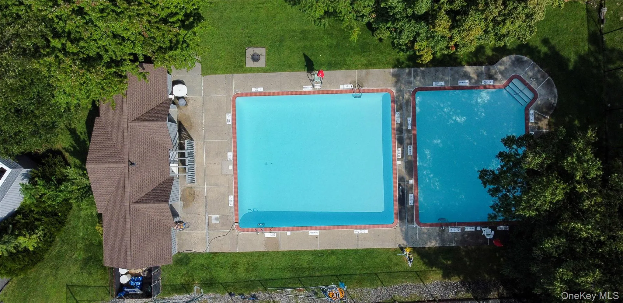 Expansive pool area featuring separate swimming areas and surrounding lawn. Expansive pool area featuring separate swimming areas and surrounding lawn.