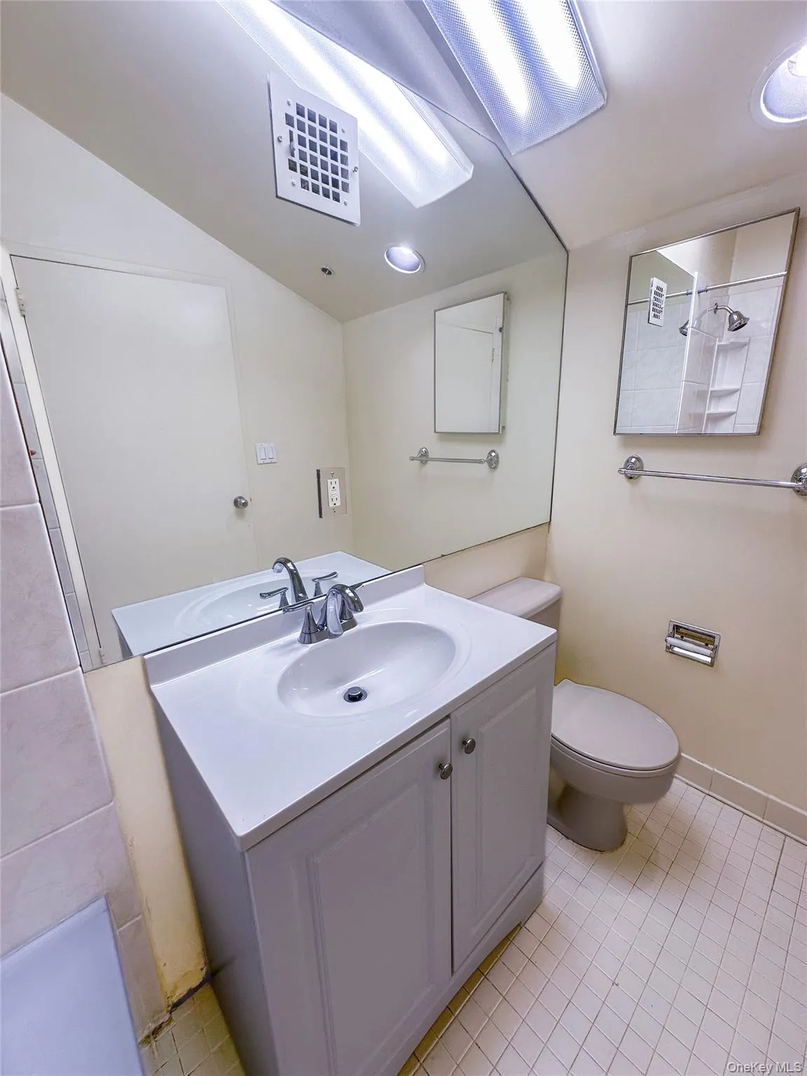 Bright bathroom featuring a tub/shower combination, updated vanity, and generous mirror. Bright bathroom featuring a tub/shower combination, updated vanity, and generous mirror.