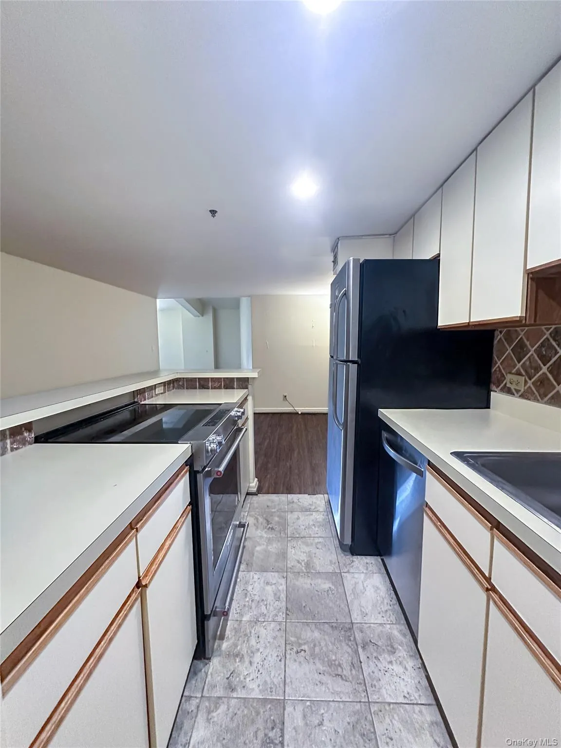 Walk-through kitchen featuring stainless steel appliances, ample cabinetry, and generous counter space. Walk-through kitchen featuring stainless steel appliances, ample cabinetry, and generous counter space.