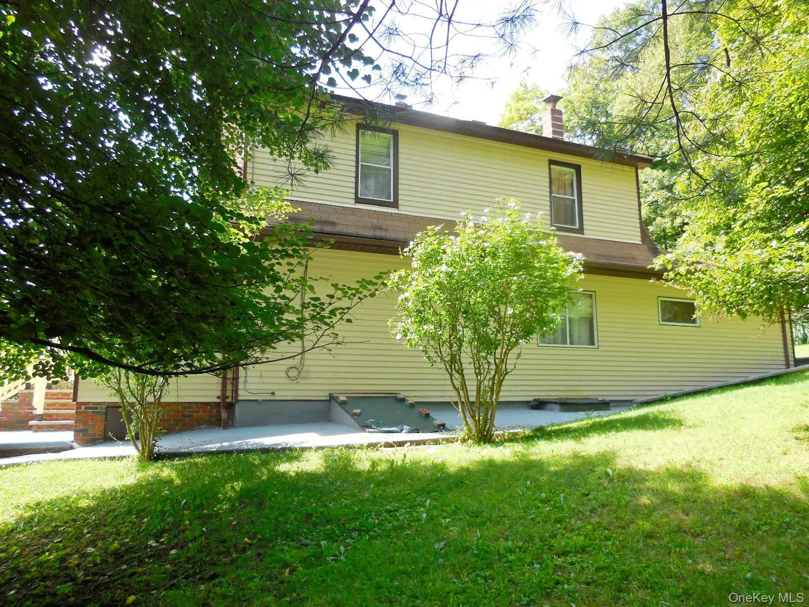 side yard & view of home with walkway and bilco doors to basement. side yard & view of home with walkway and bilco doors to basement.