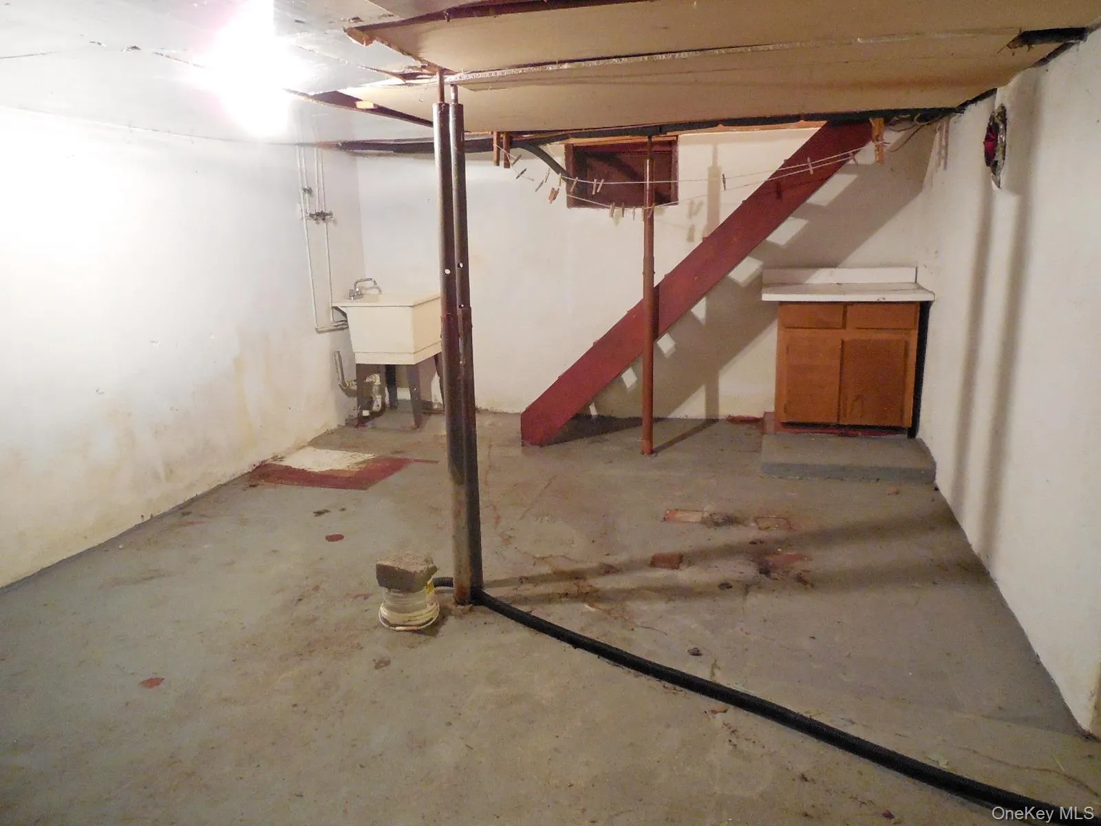 Concrete floor with painted white walls and utility sink. Concrete floor with painted white walls and utility sink.
