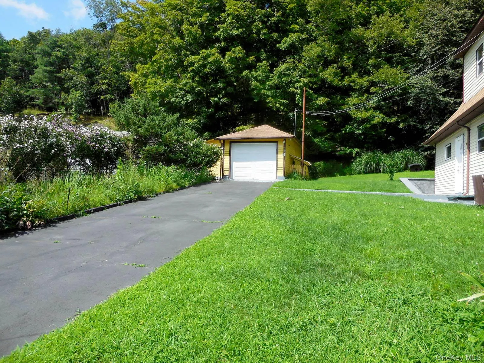 1 Car garage with storage area, black top driveway and sidewalk to side entry of home. 1 Car garage with storage area, black top driveway and sidewalk to side entry of home.
