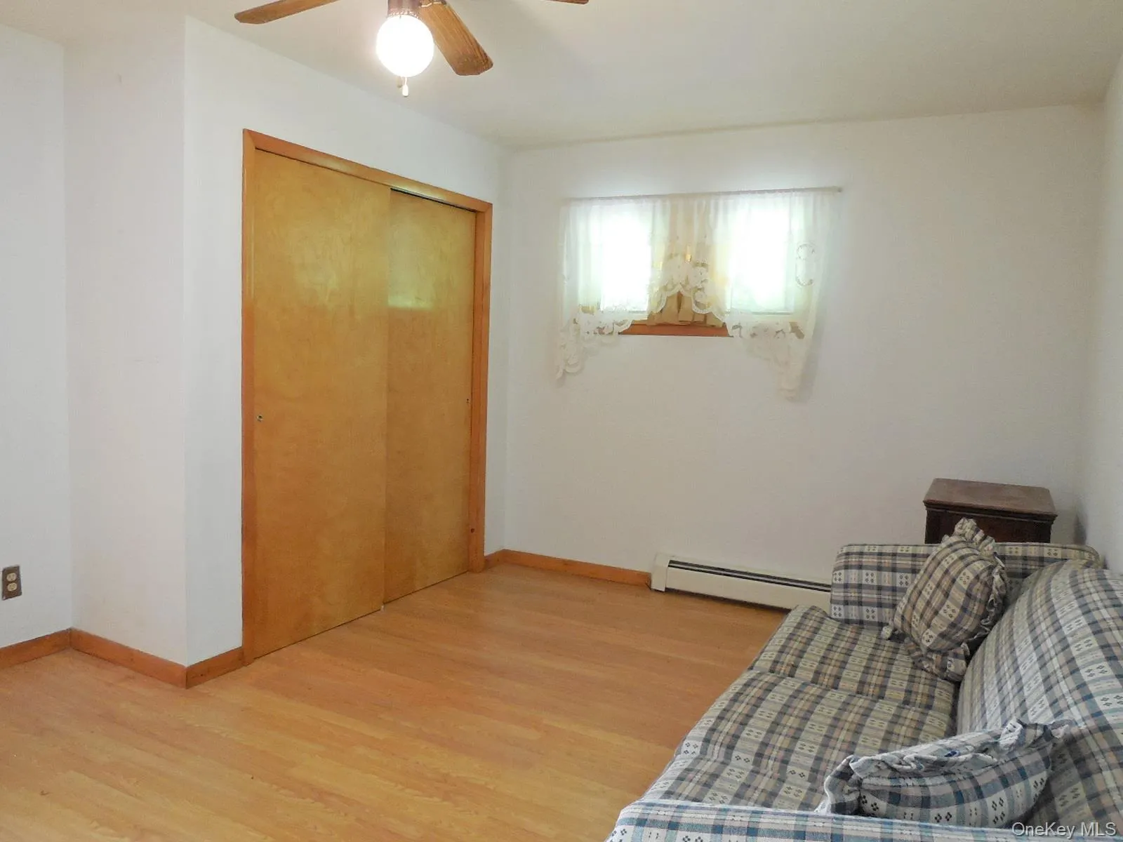 Wood-finish flooring, light wood trim, and a ceiling fan with integrated lighting Wood-finish flooring, light wood trim, and a ceiling fan with integrated lighting