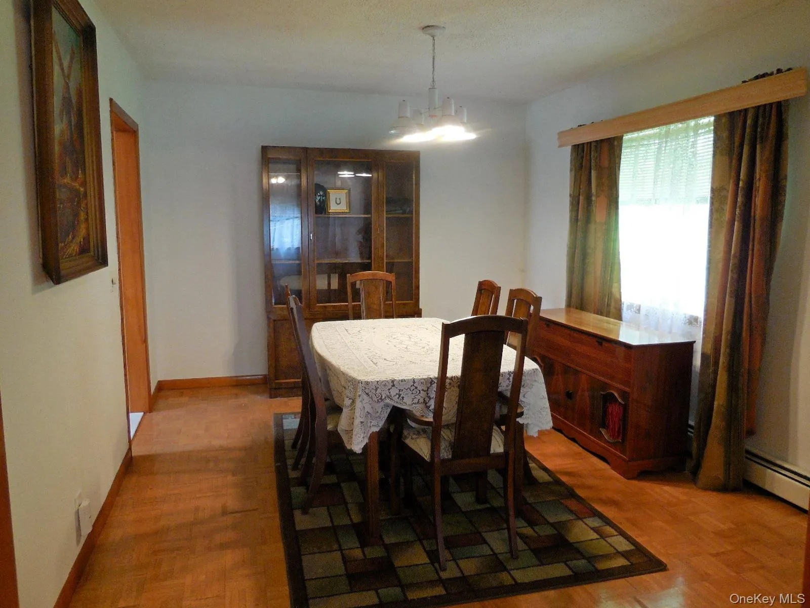 Hardwood flooring throughout, oversized window with valance, and a ceiling-mounted light fixture Hardwood flooring throughout, oversized window with valance, and a ceiling-mounted light fixture