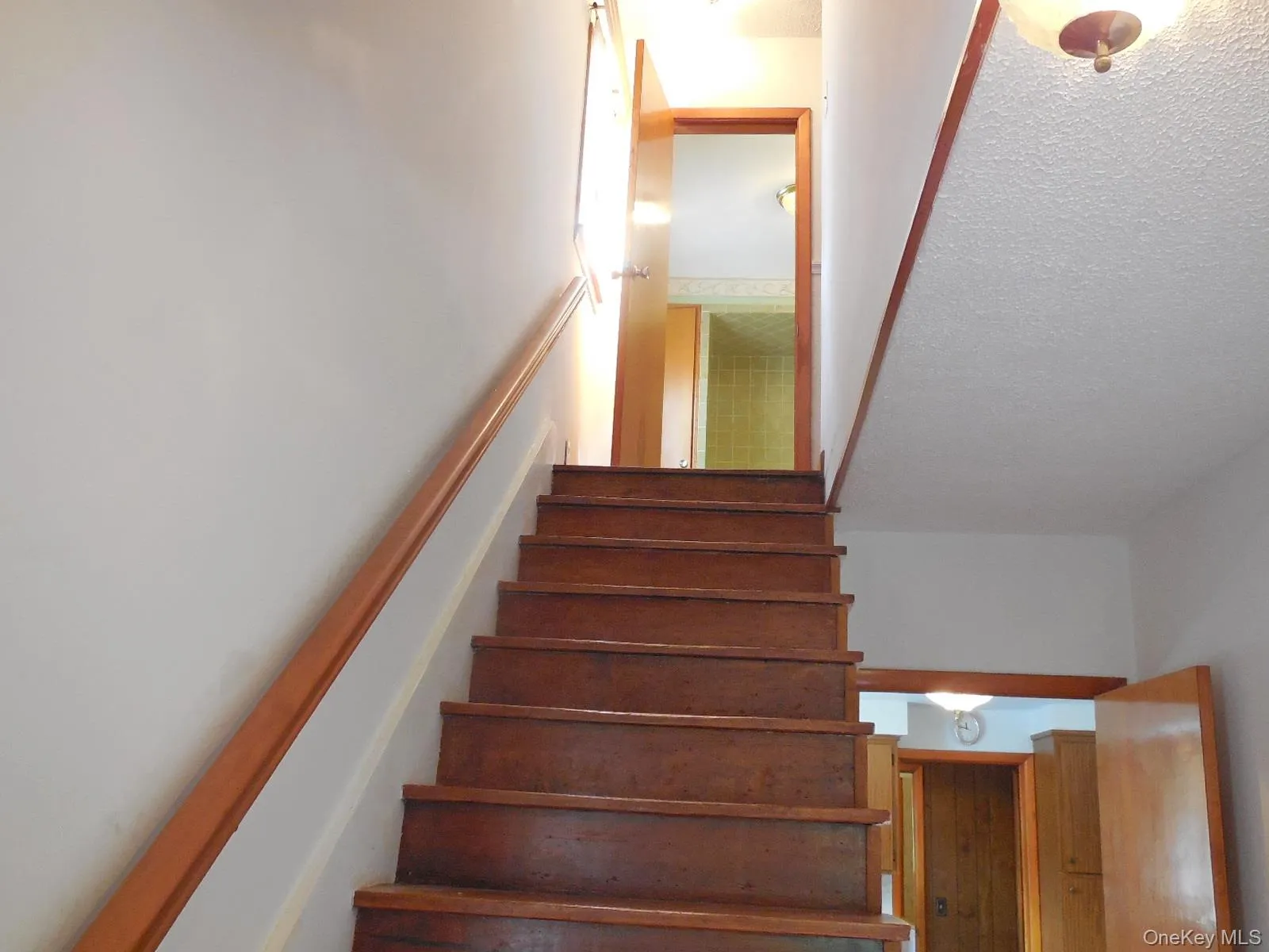 Staircase with wood treads and a wood handrail to second floor Staircase with wood treads and a wood handrail to second floor