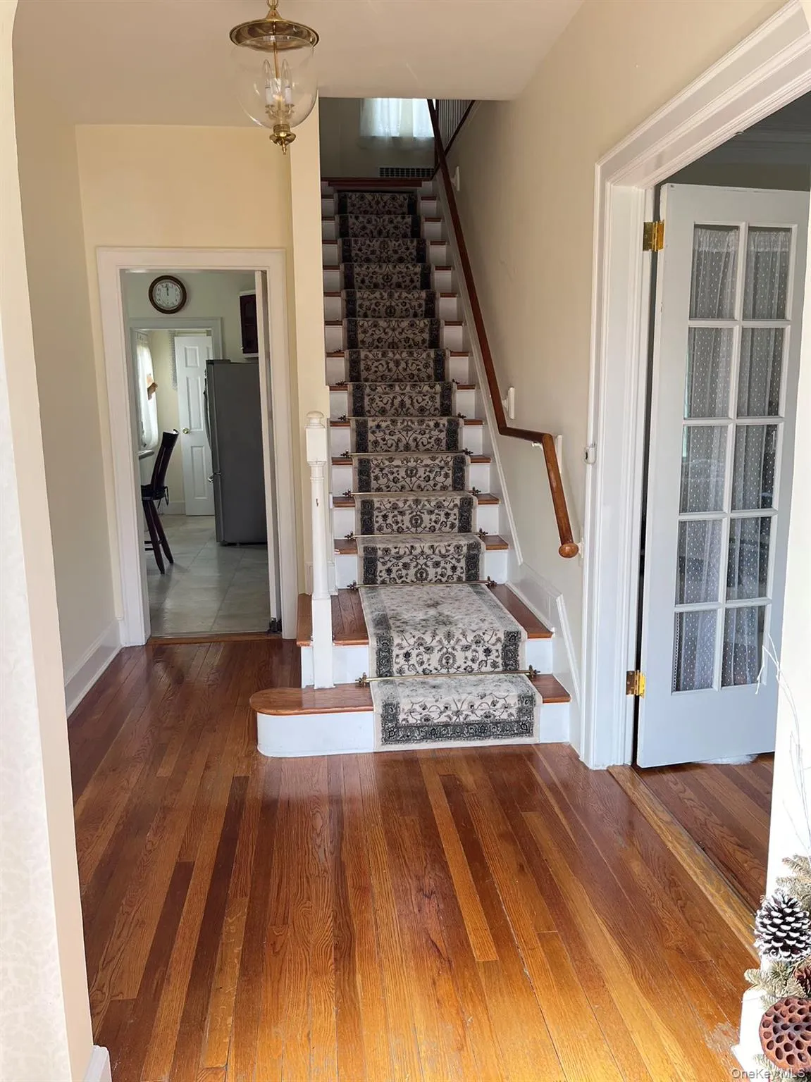 Hardwood flooring throughout, staircase with carpet runner, traditional chandelier, and French doors Hardwood flooring throughout, staircase with carpet runner, traditional chandelier, and French doors