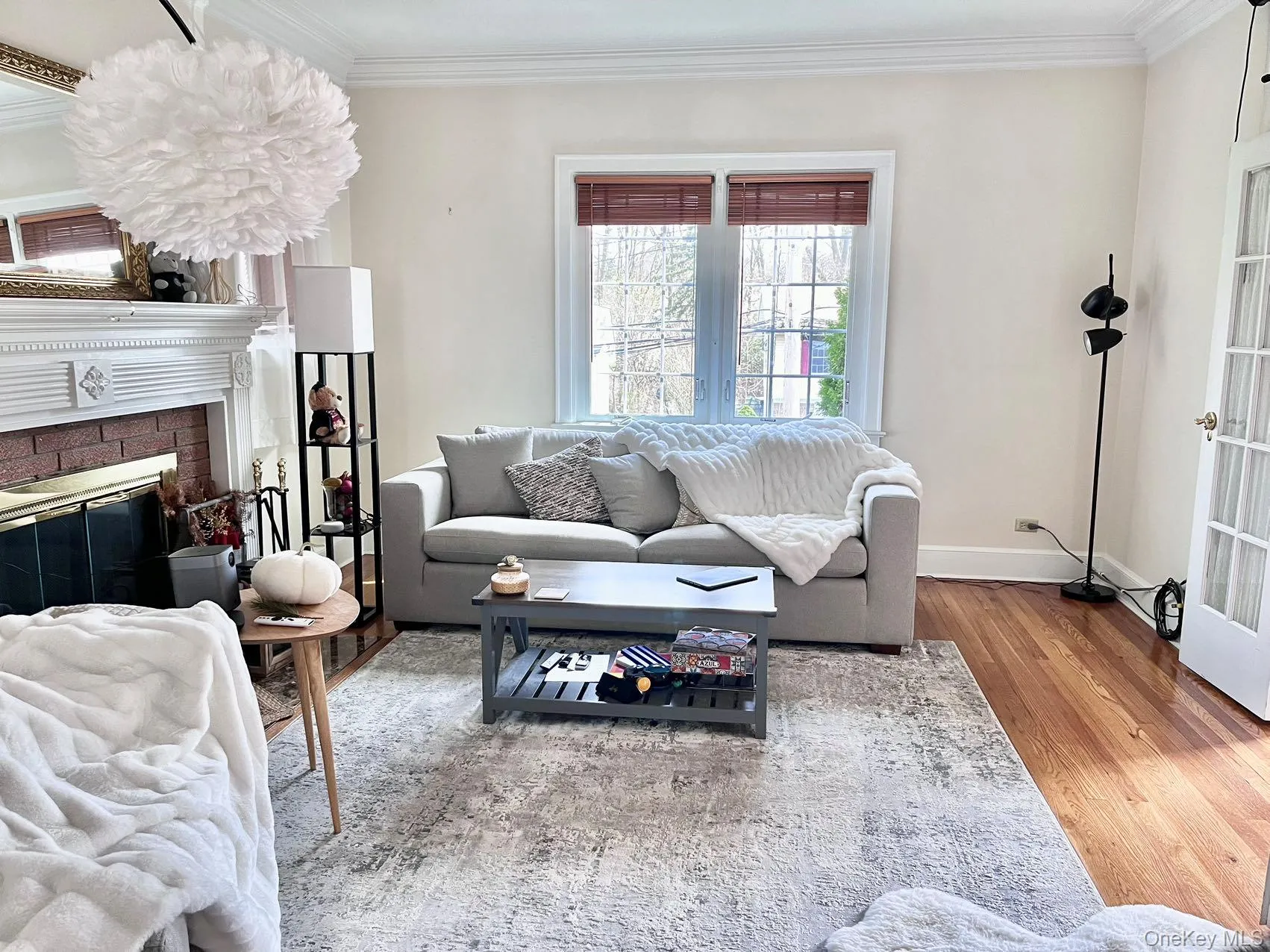 Hardwood flooring, crown molding, double windows with blinds, brick fireplace with mantel, and French doors Hardwood flooring, crown molding, double windows with blinds, brick fireplace with mantel, and French doors