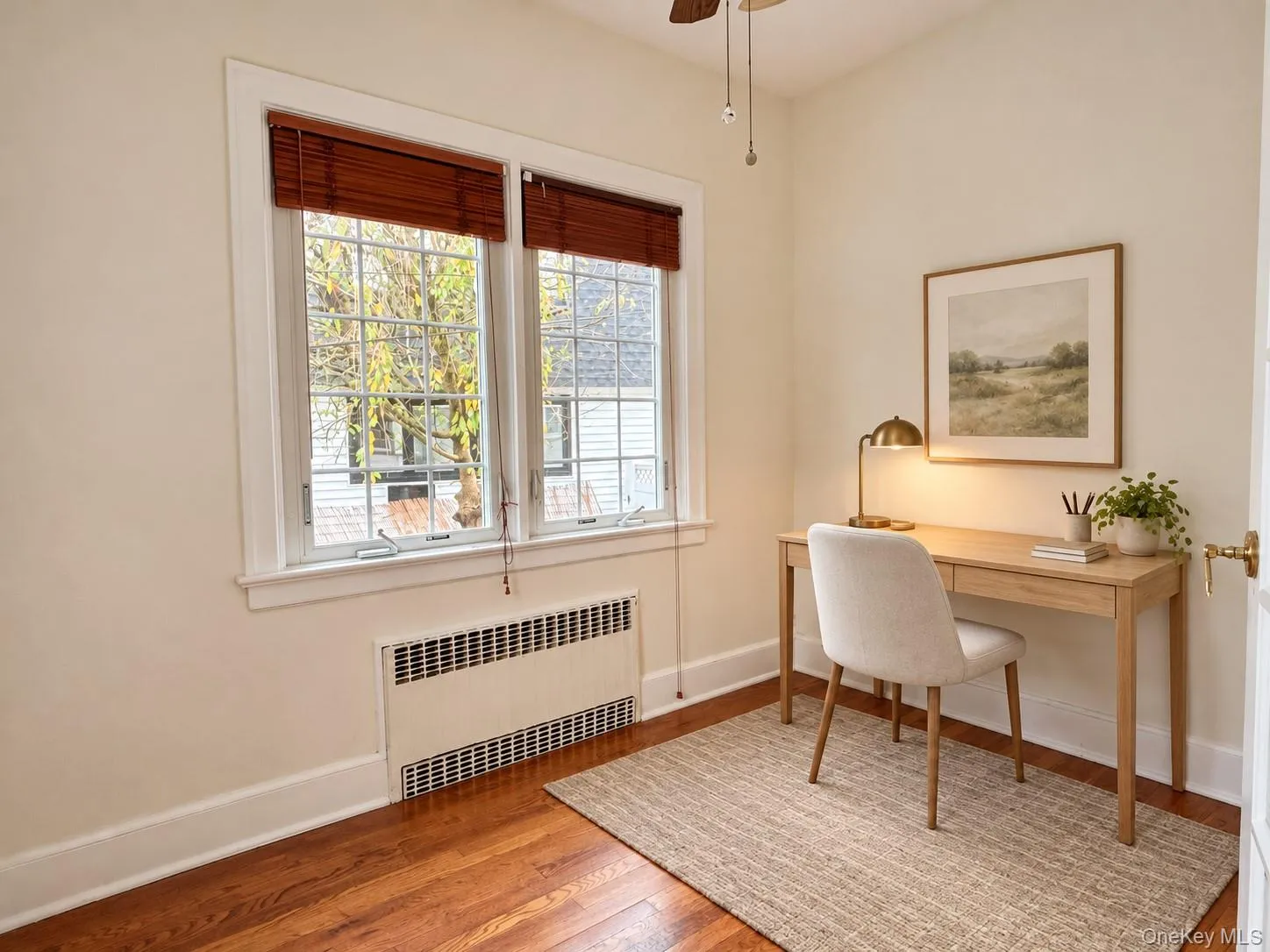 Wood-finish flooring, dual-pane windows with grid detailing, and recessed wall-integrated heating unit Wood-finish flooring, dual-pane windows with grid detailing, and recessed wall-integrated heating unit